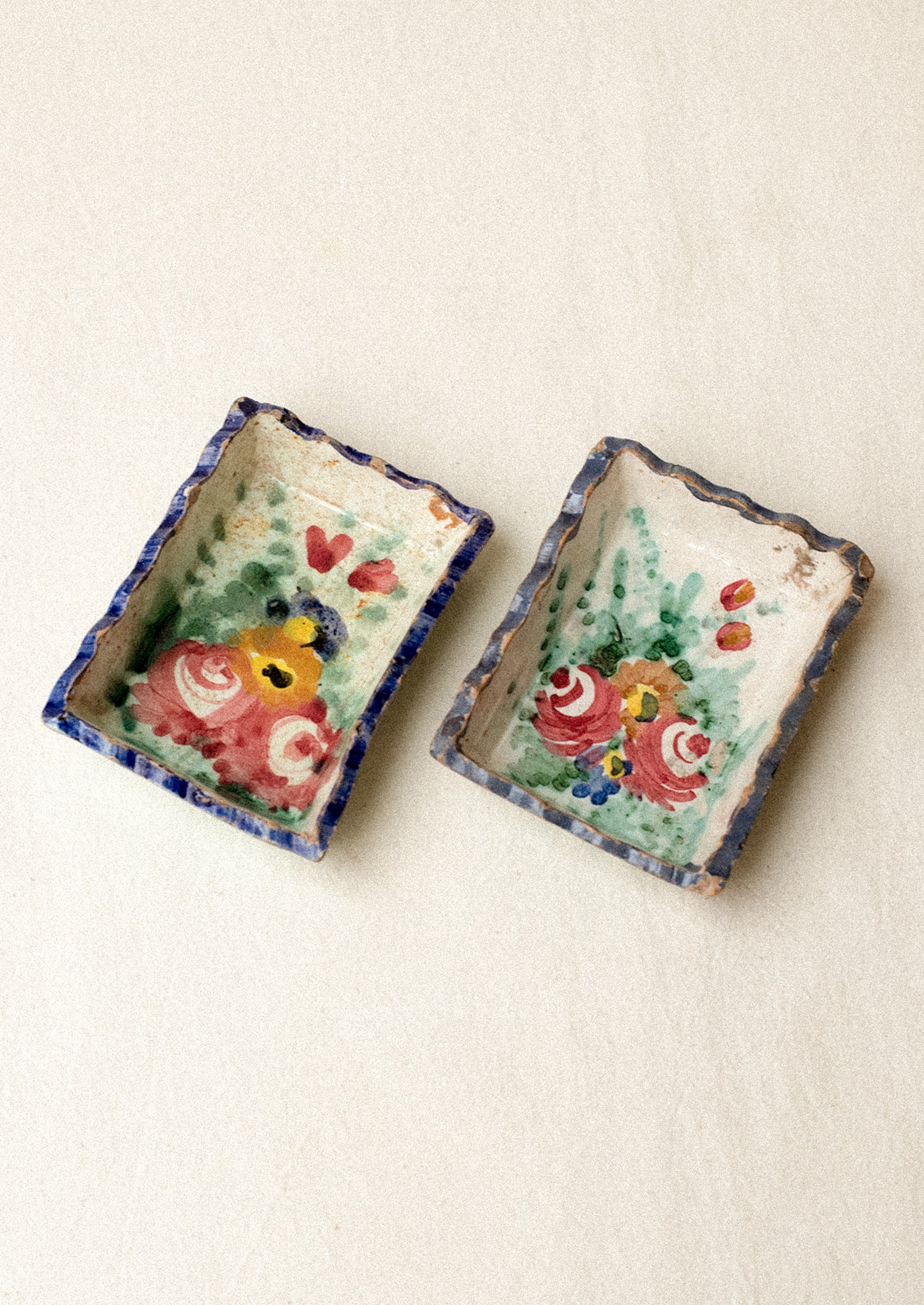 Two small rectangular ceramic trays with floral designs.