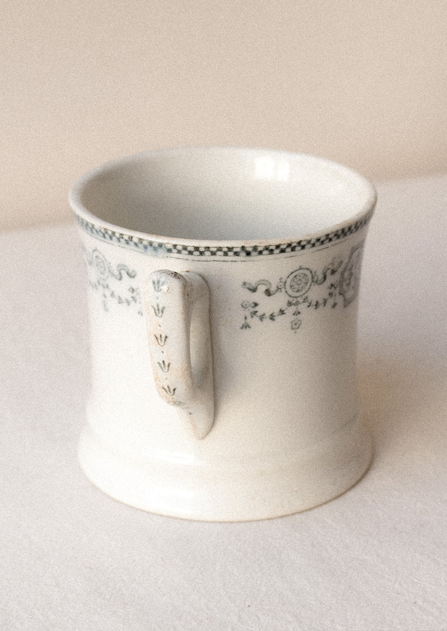 An antique English transferware mug with checkered lace pattern.