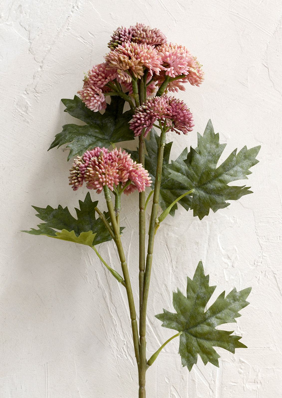 A faux floral stem depicting pink sedum with leaves.