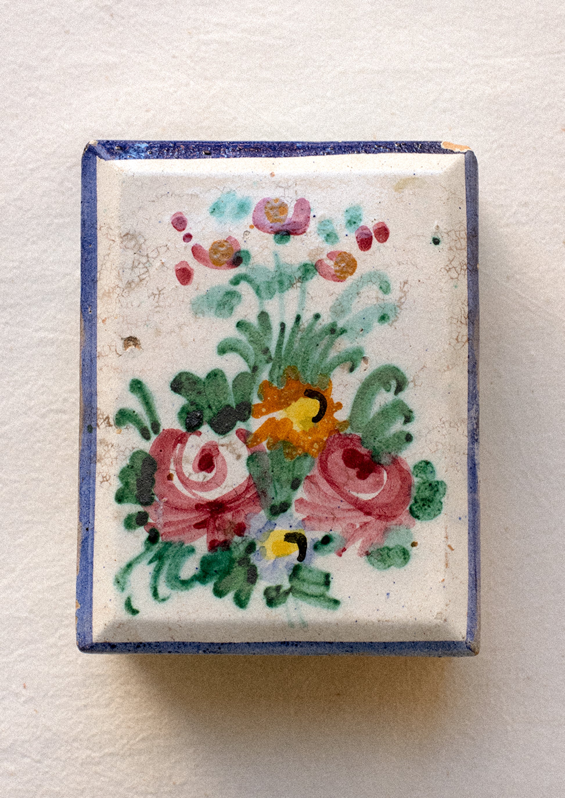 Decorative ceramic box with floral patterns on a plain background