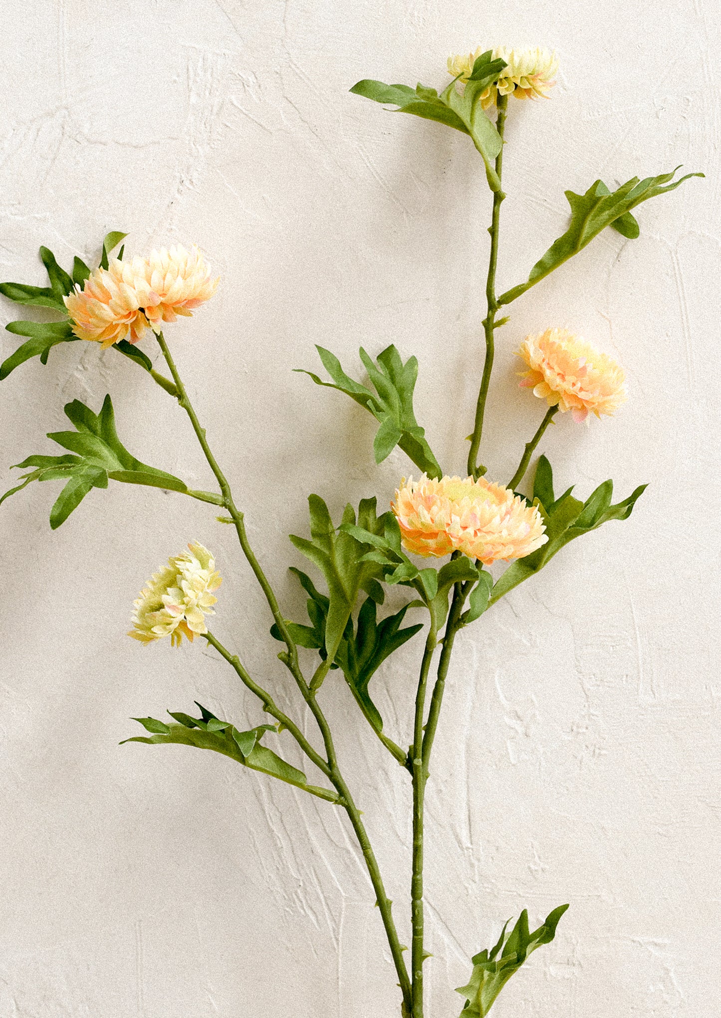A faux floral spray depicting orange strawflower.