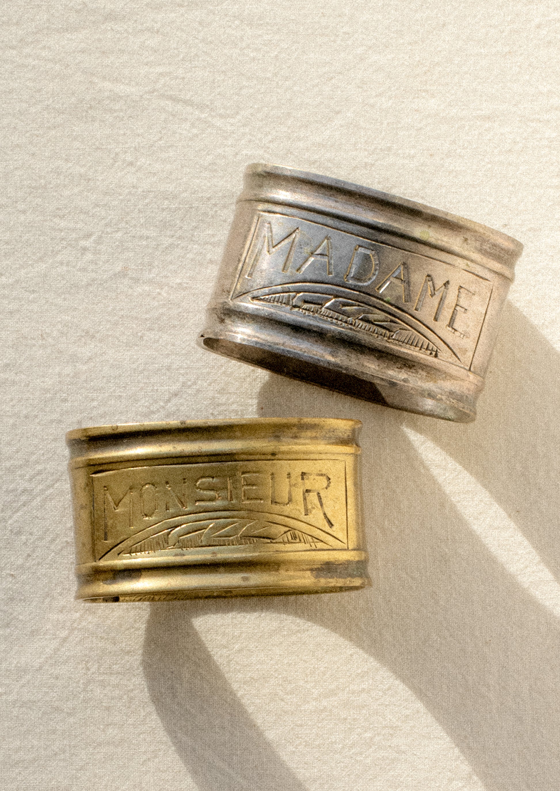 A pair of napkin rings in silver and brass.