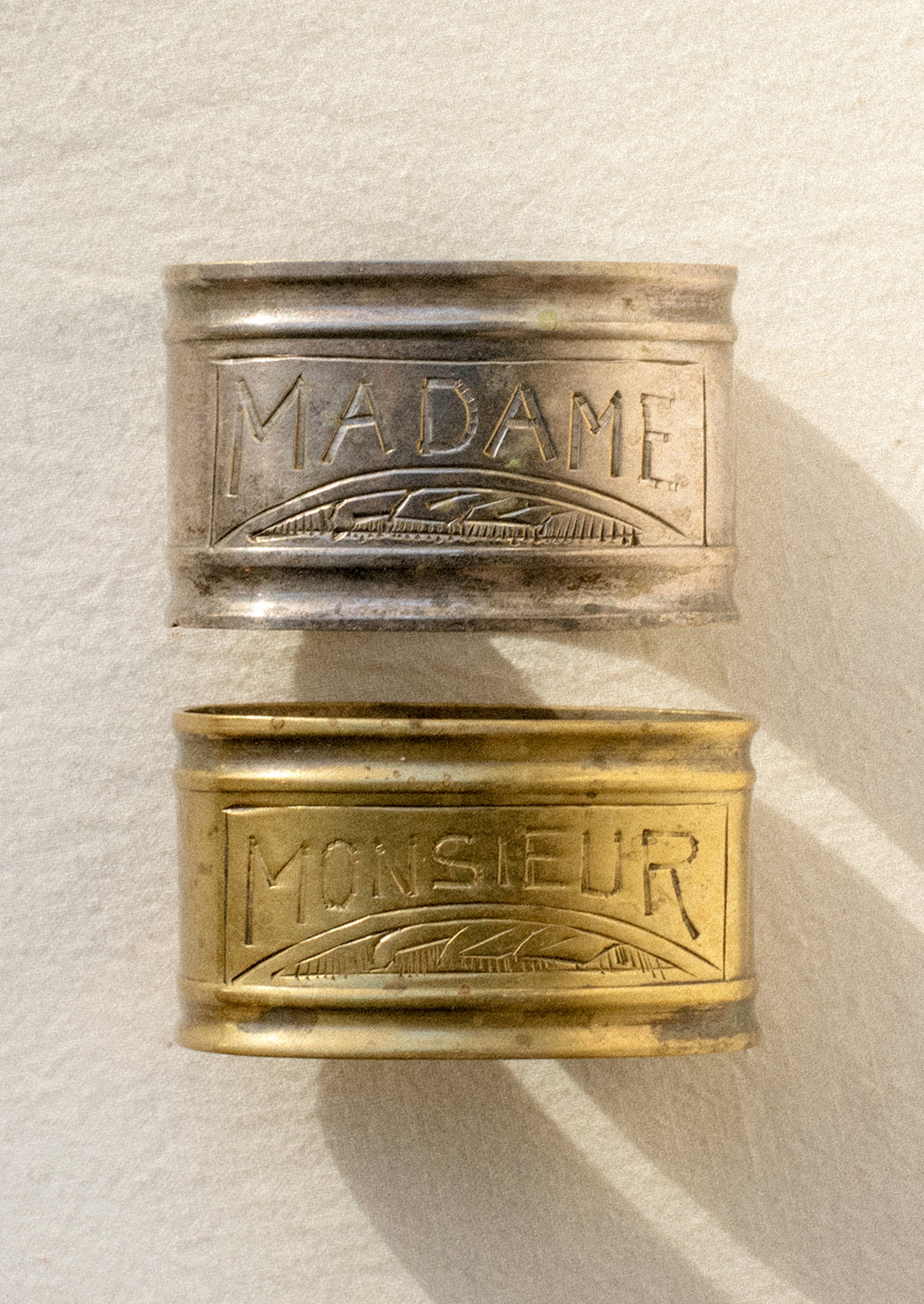 A pair of napkin rings in silver and brass.