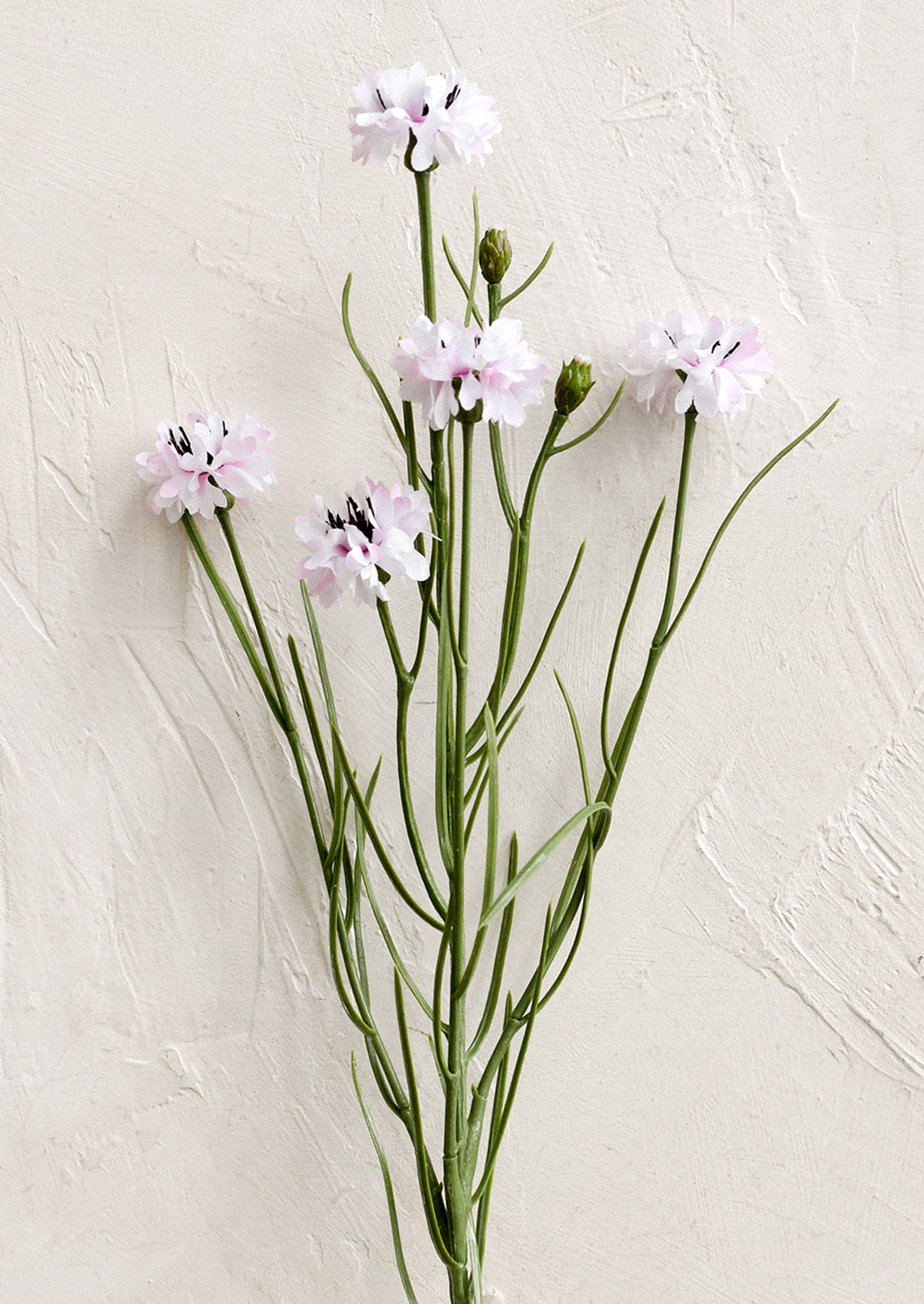 A faux floral spray depicting mini cornflower in pink.