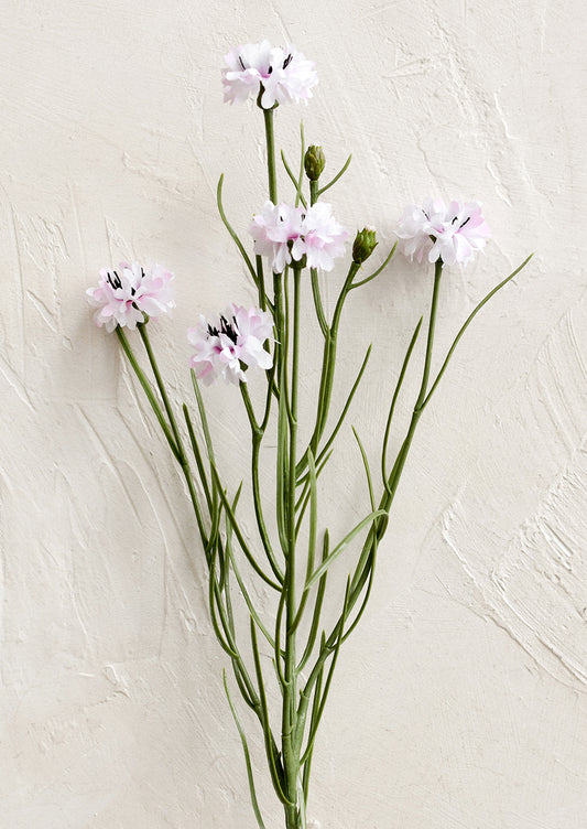 A faux floral spray depicting mini cornflower in pink.