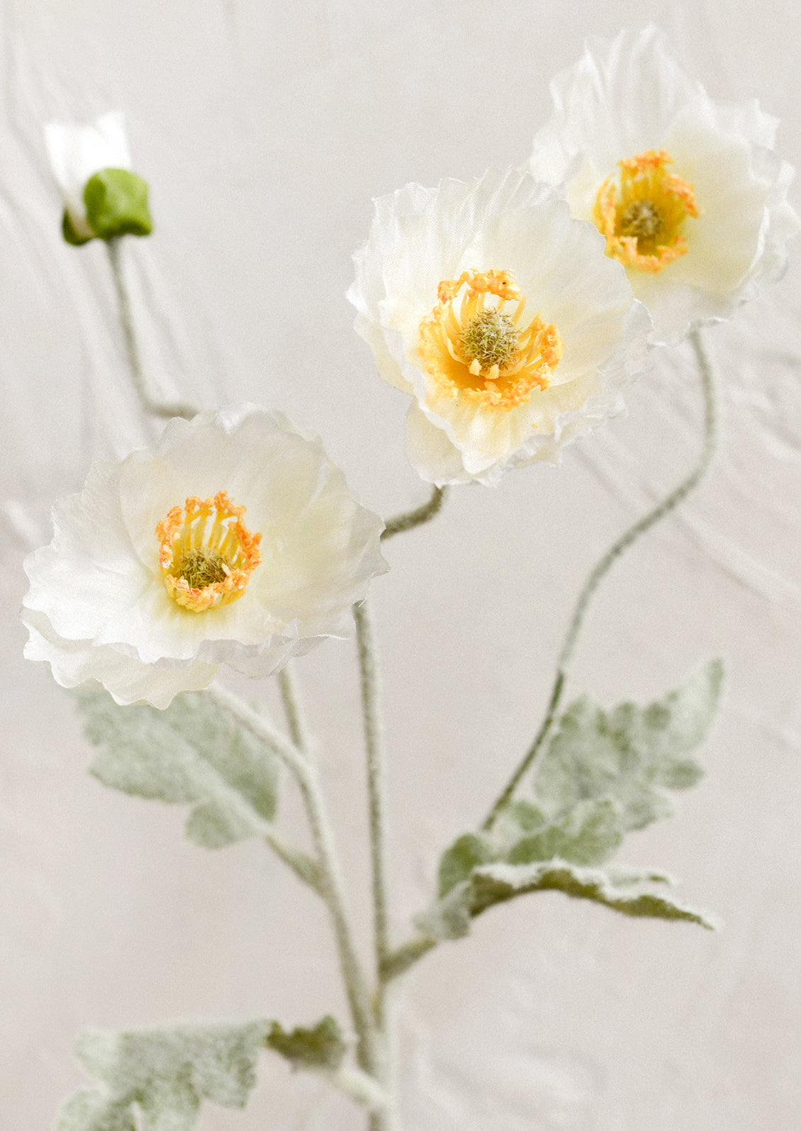 A faux floral stem depicting icelandic poppy flower in white color.