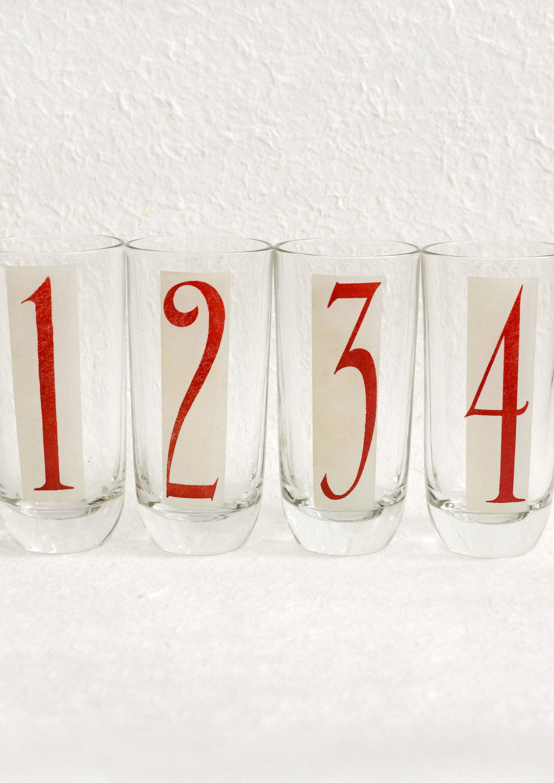 A set of high ball glasses with frosted red and white digit decal on each glass, numbering 1 through 6.