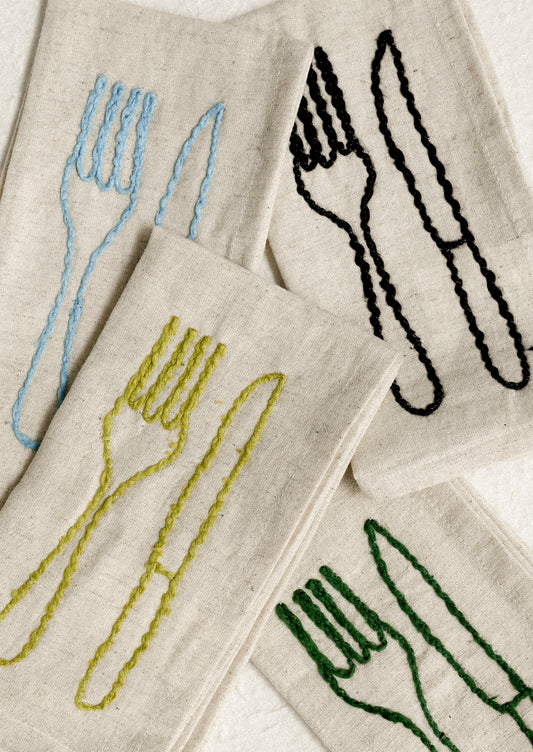 A set of natural linen napkins with embroidered fork and knife motif in assorted colors.