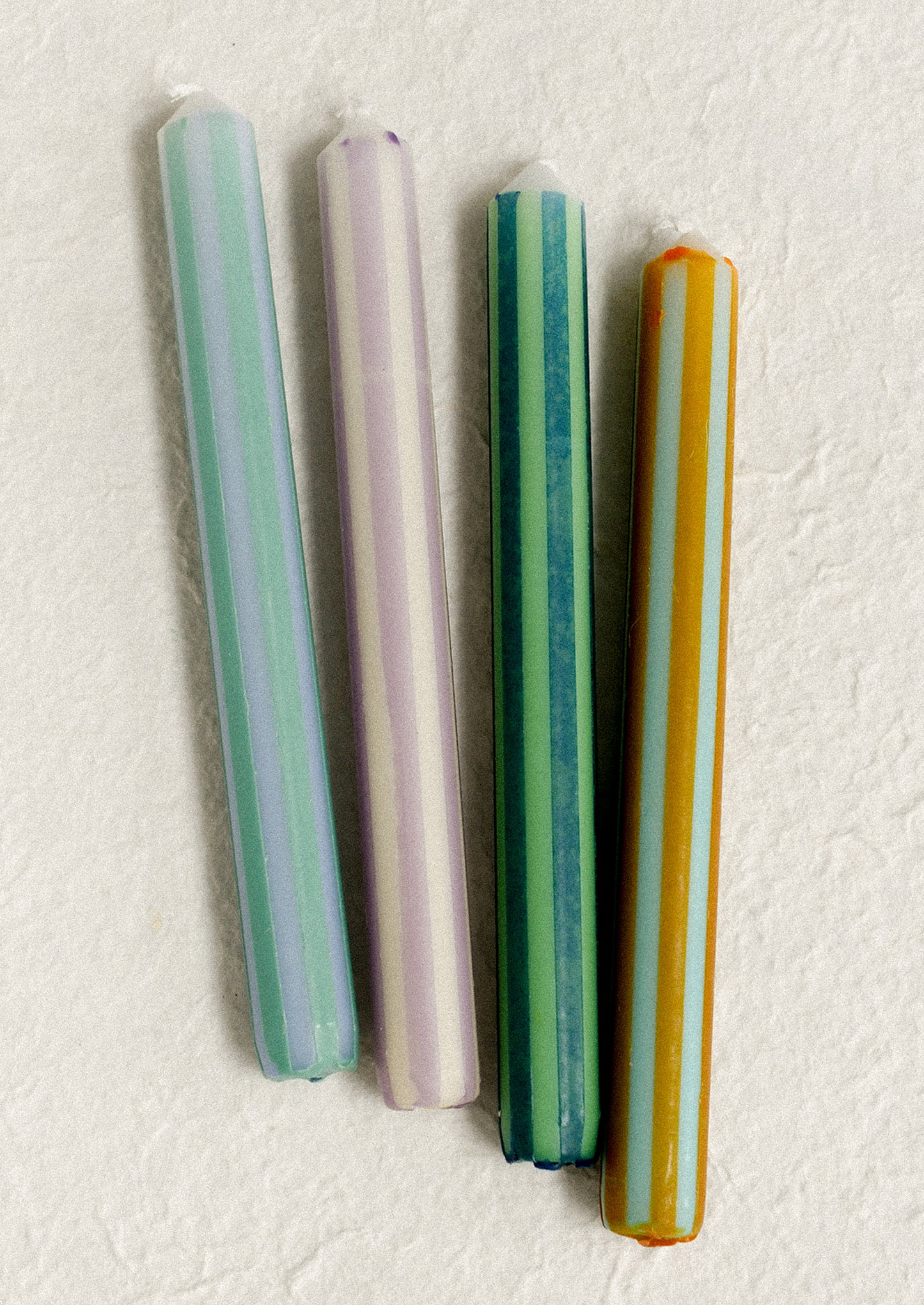 Pinstripe print taper candles in four color options.