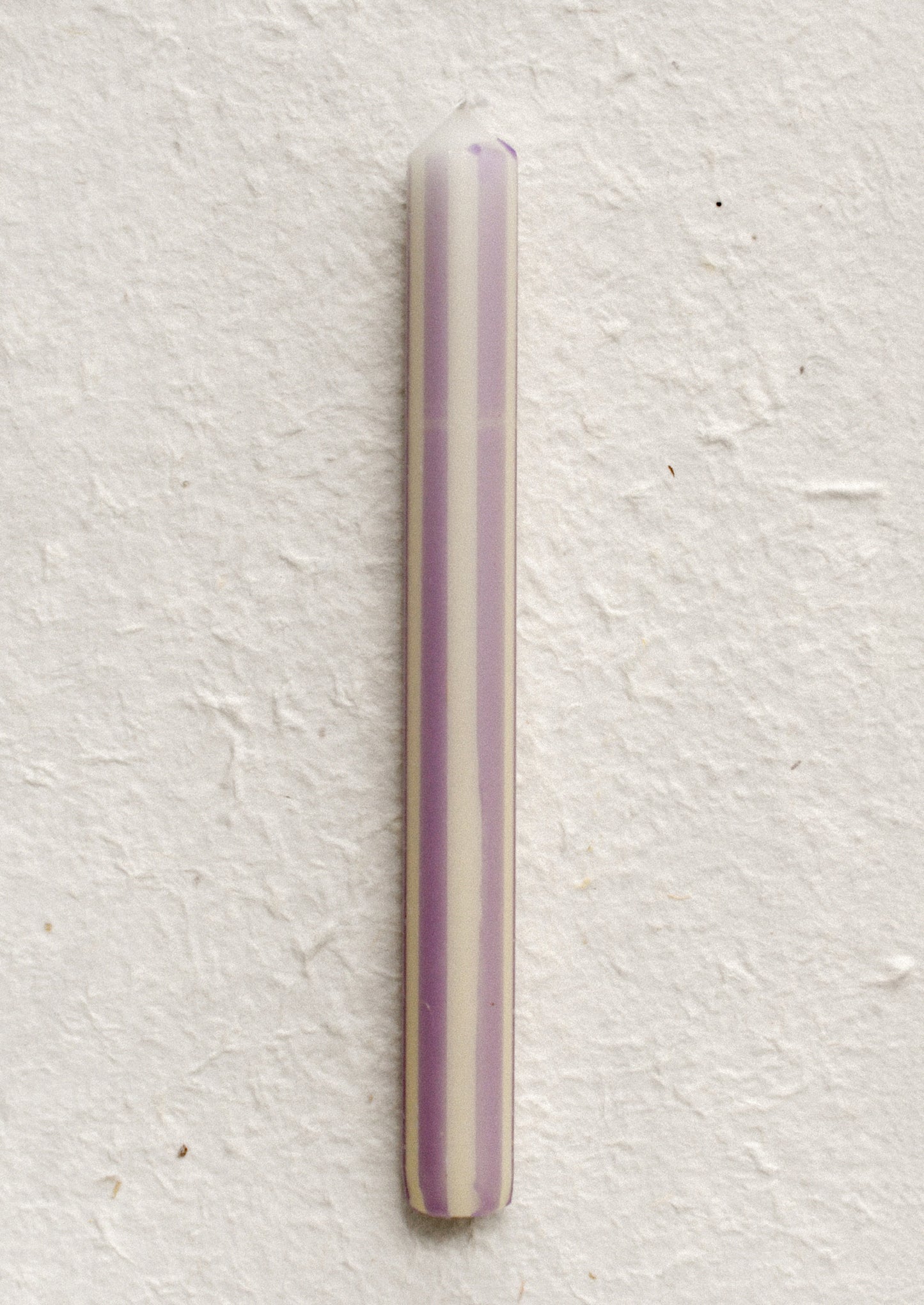 A pinstripe patterned candle in ivory and lavender stripes.