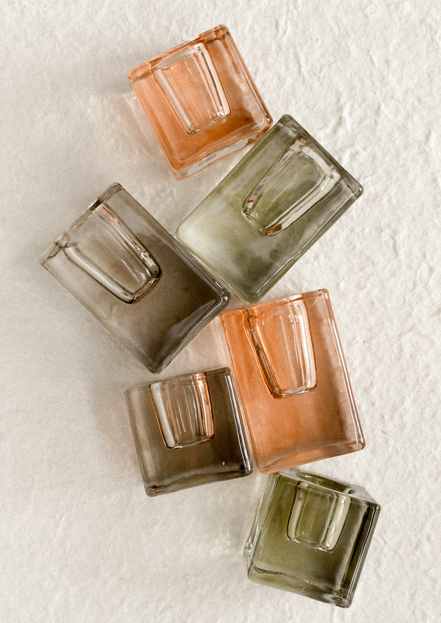 Cube-shaped slab glass candleholders in assorted colors.