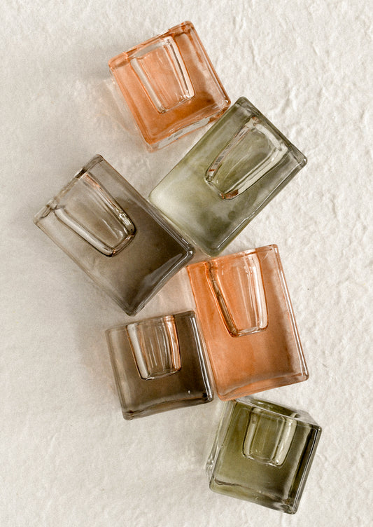 Cube-shaped slab glass candleholders in assorted colors.