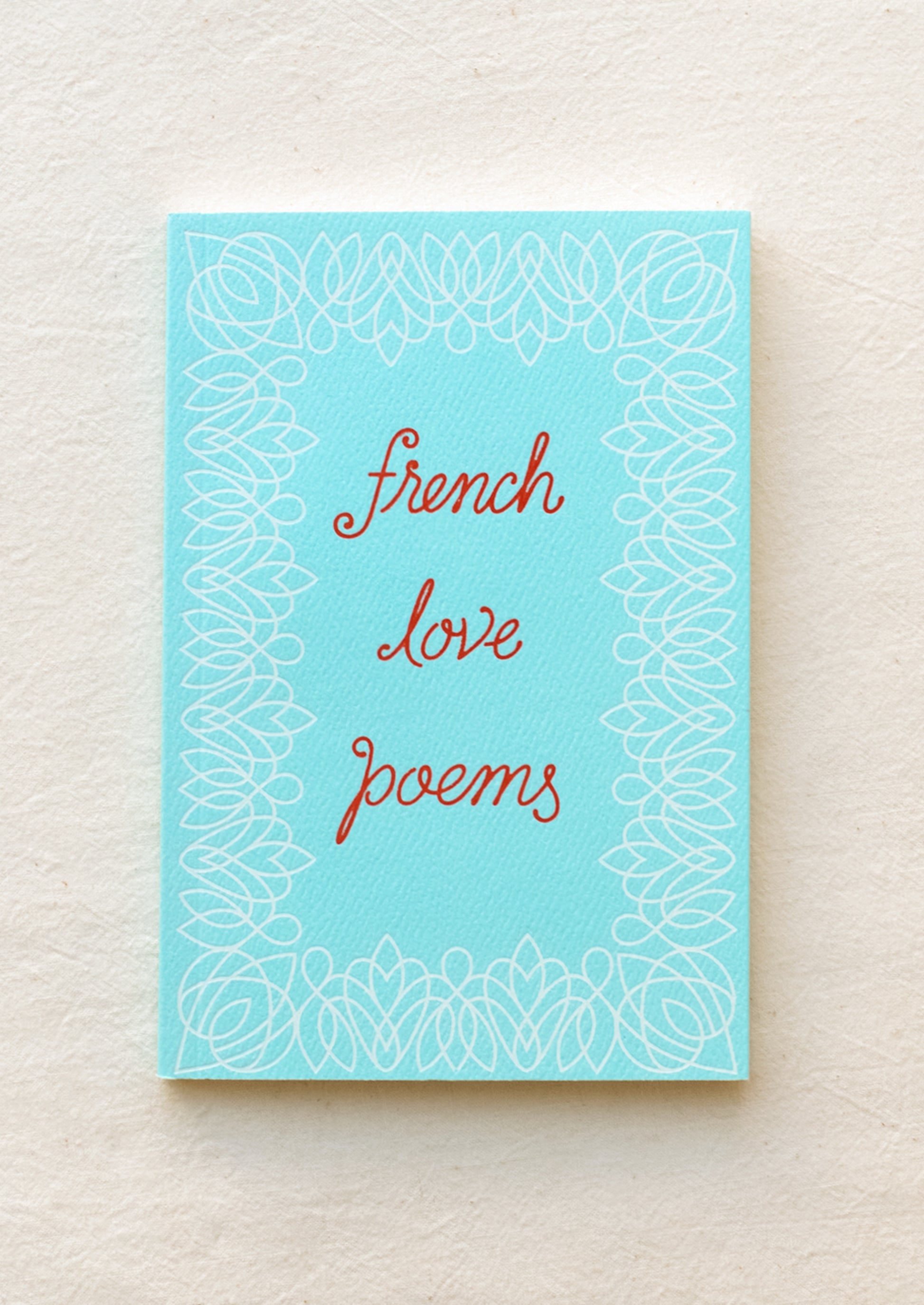 Small blue book with red writing featuring the text "french love poems".