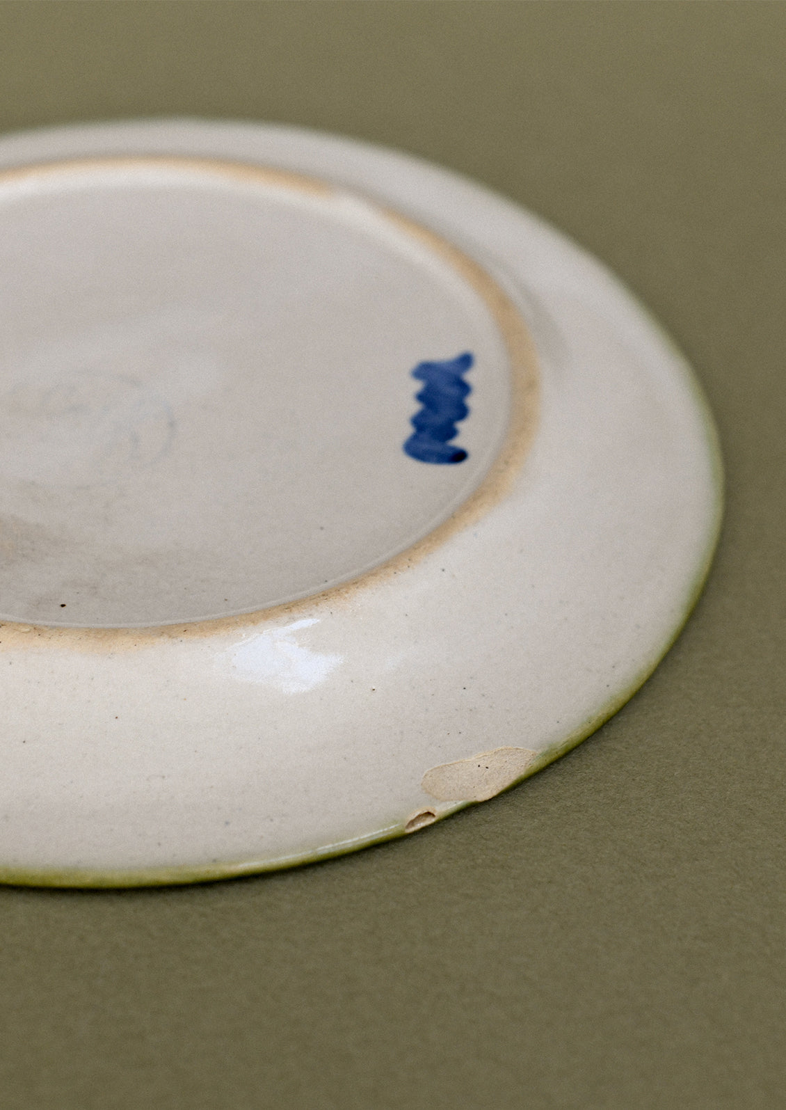A pair of floral and squiggle painted plates in green, blue and orange.