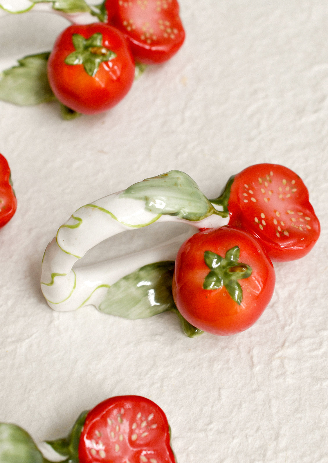 A set of 4 napkin rings with tomato motif.