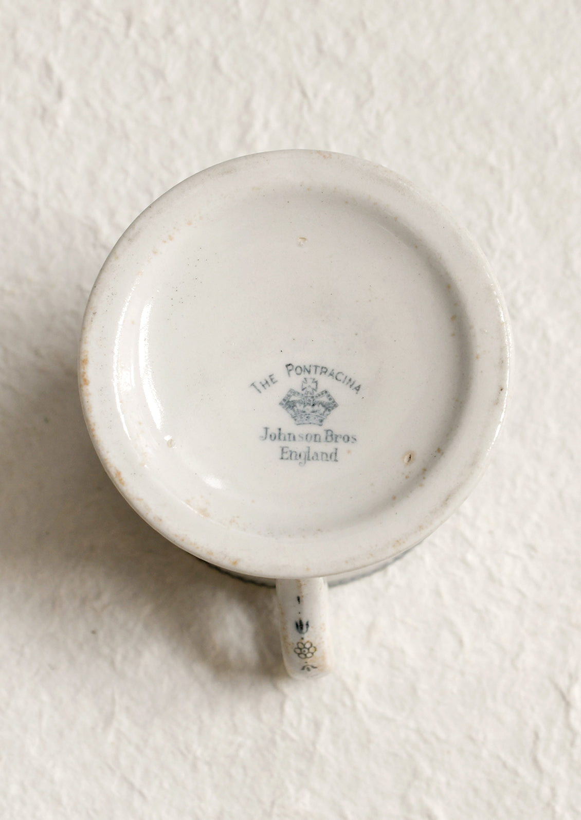 An antique English transferware mug with checkered lace pattern.