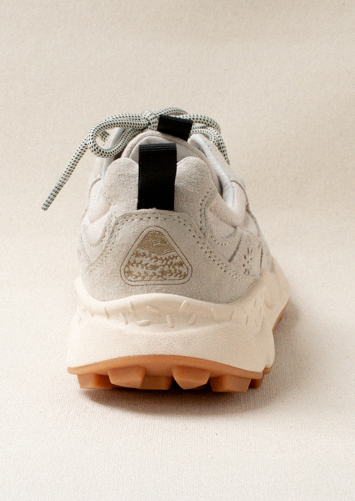 A pair of sporty sneakers in A pair of sporty sneakers in neutral colors with flower cutout detailing.neutral colors with flower cutout detailing.