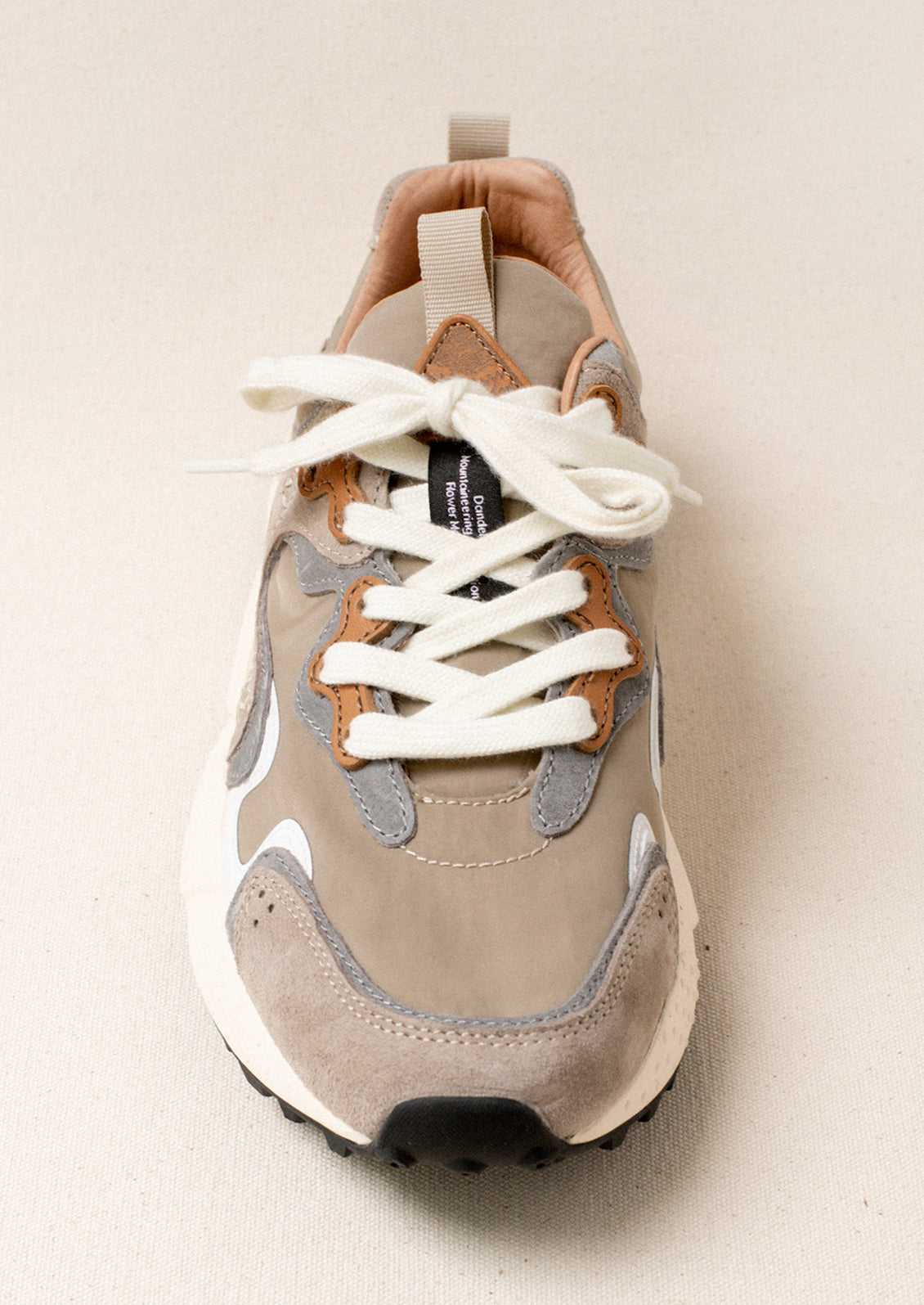 A sporty unisex sneaker in taupe, grey and brown.