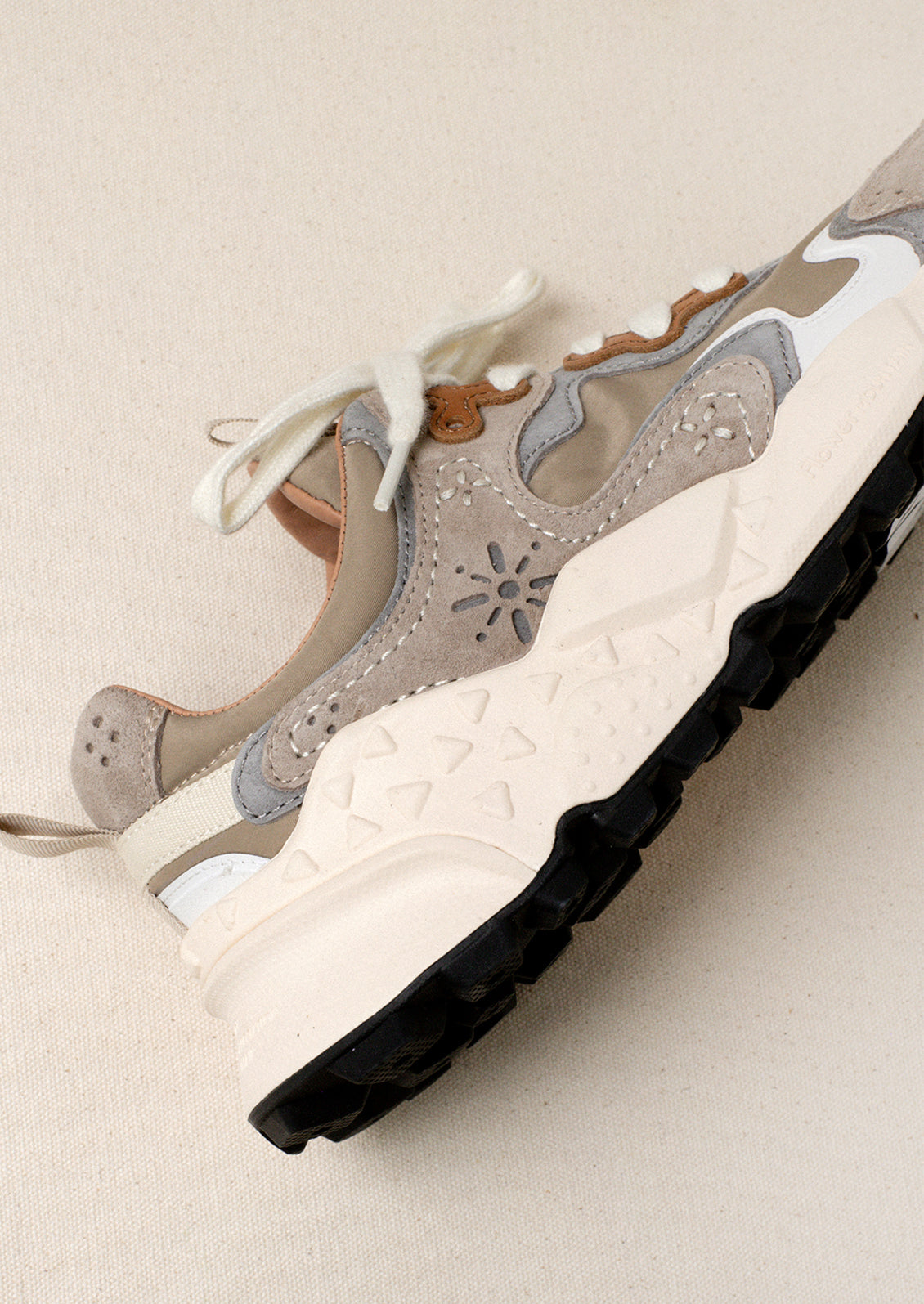 A sporty unisex sneaker in taupe, grey and brown.