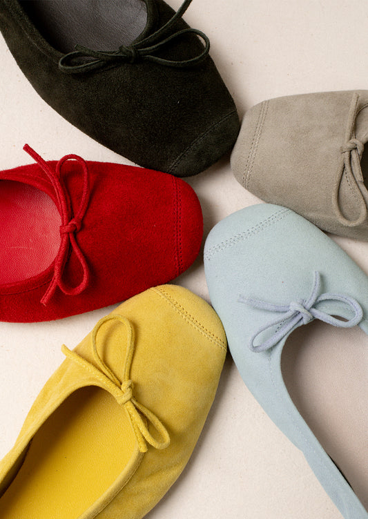 A circle of suede ballet flats in a variety of colors.