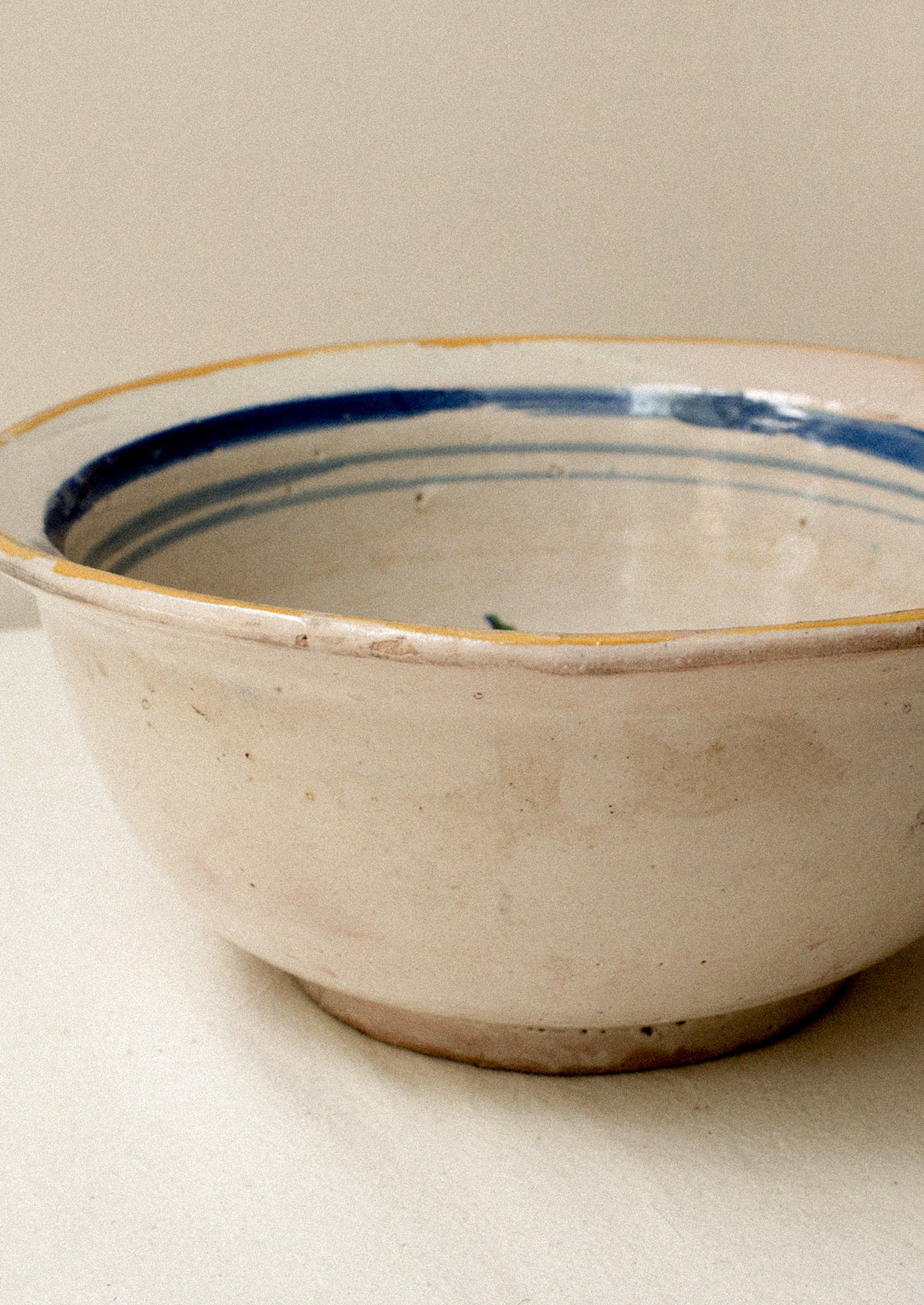 An antique ceramic serving bowl with painted blue rim.
