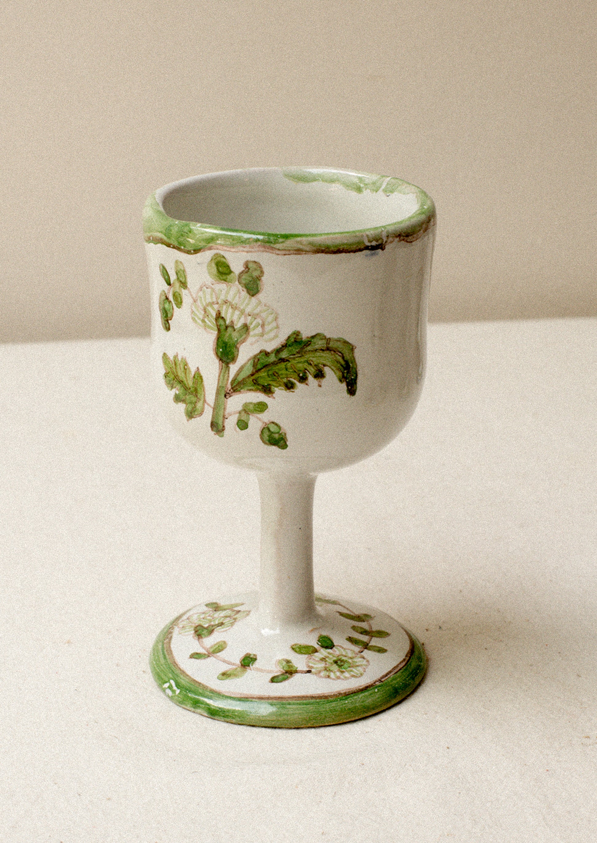 A set of four floral painted wine glasses.