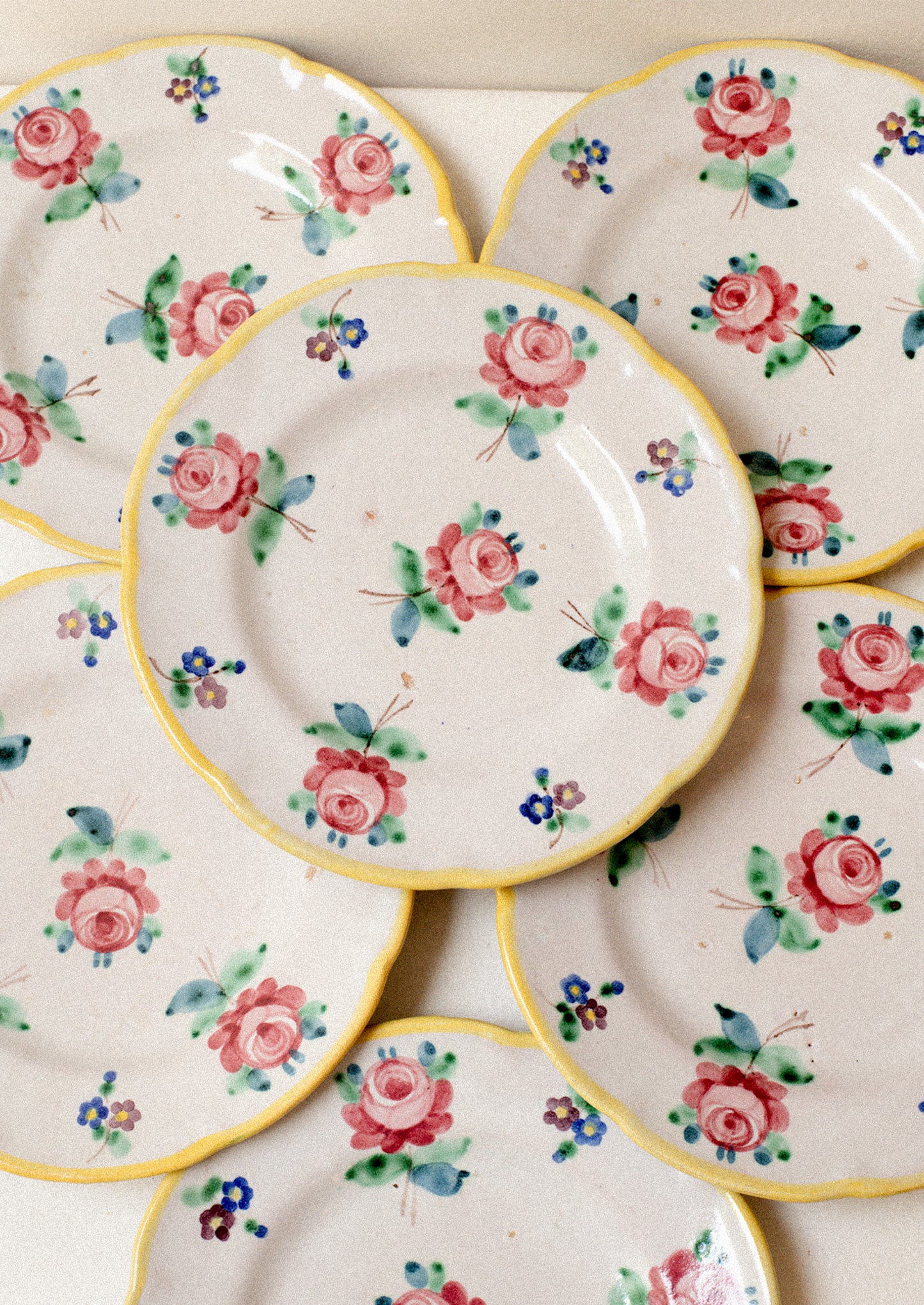 A set of vintage Italian hand painted floral plates with yellow rim.