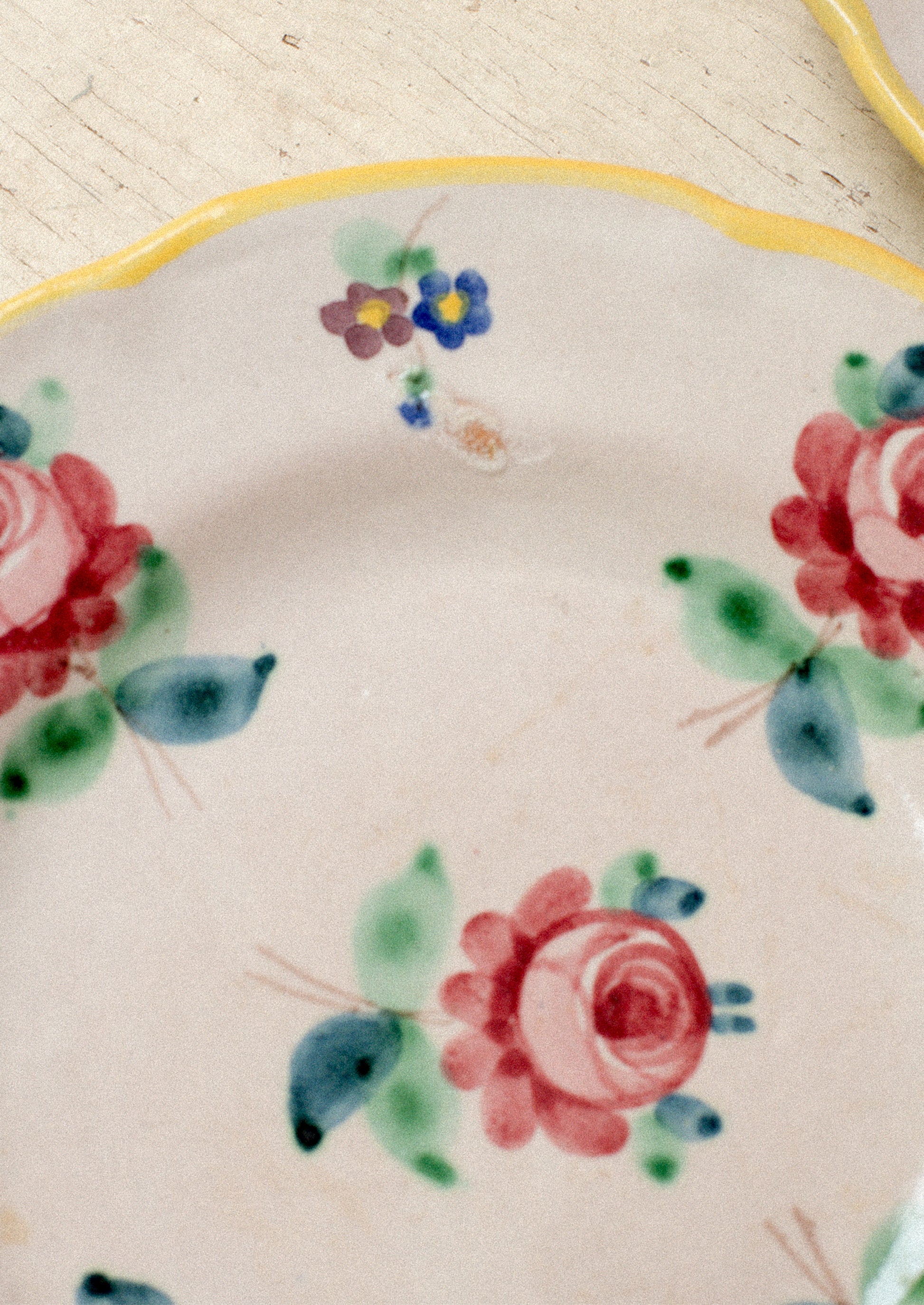 A set of vintage Italian hand painted floral plates with yellow rim.