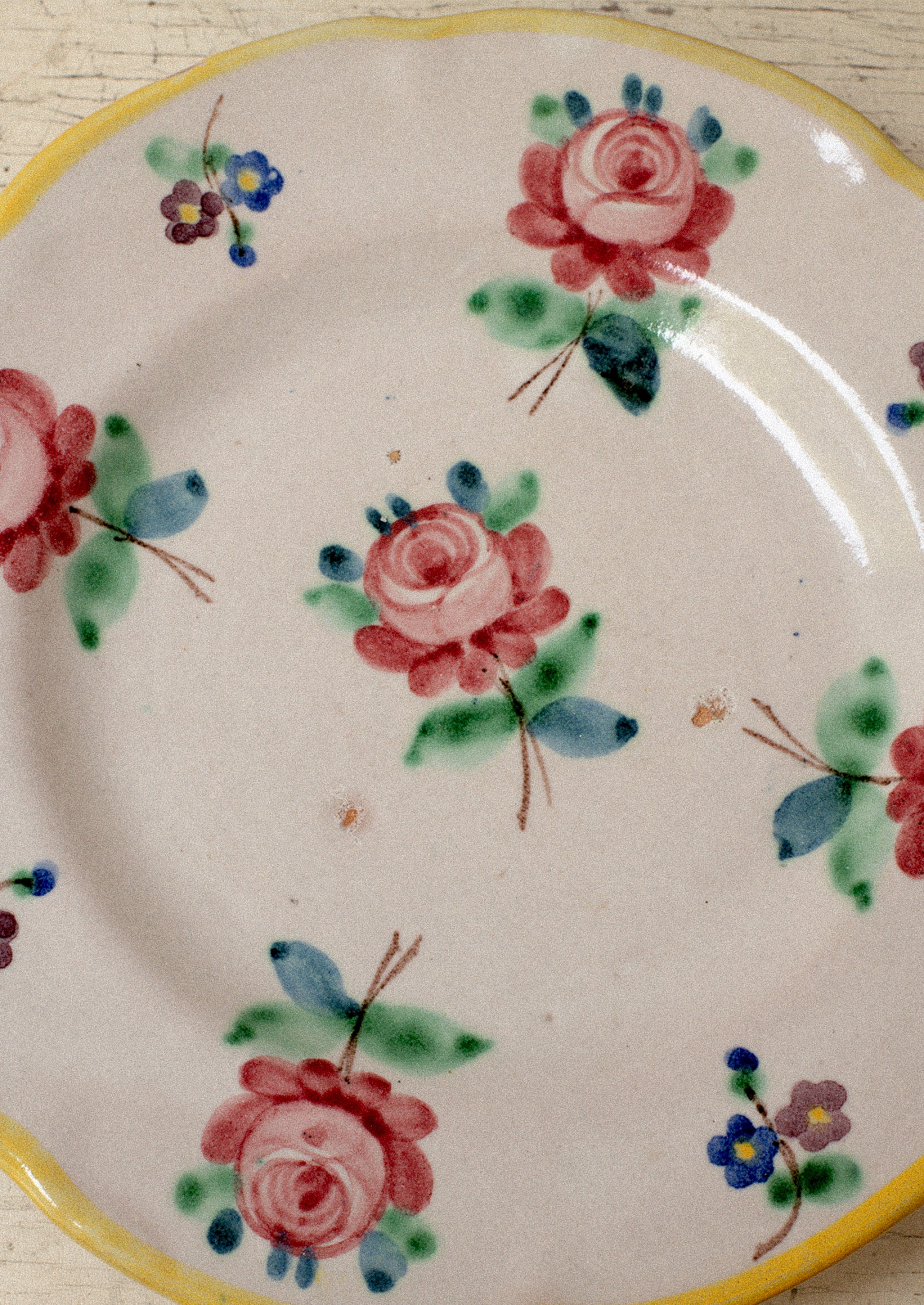 A set of vintage Italian hand painted floral plates with yellow rim.