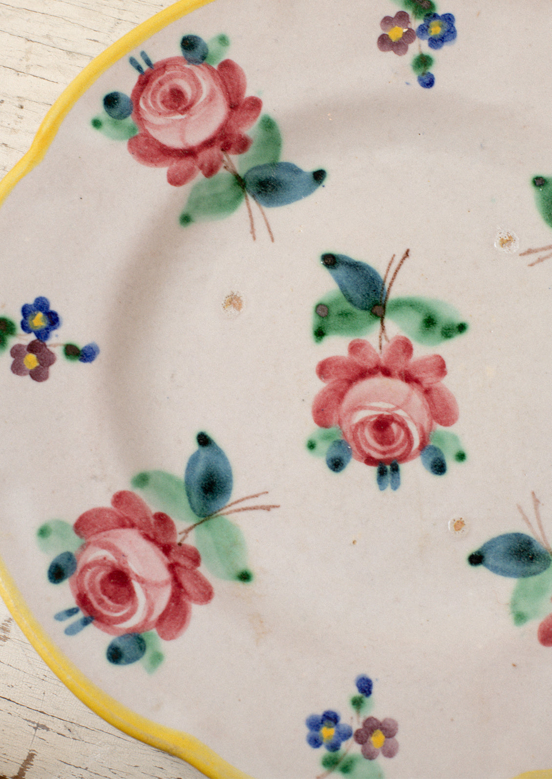 A set of vintage Italian hand painted floral plates with yellow rim.