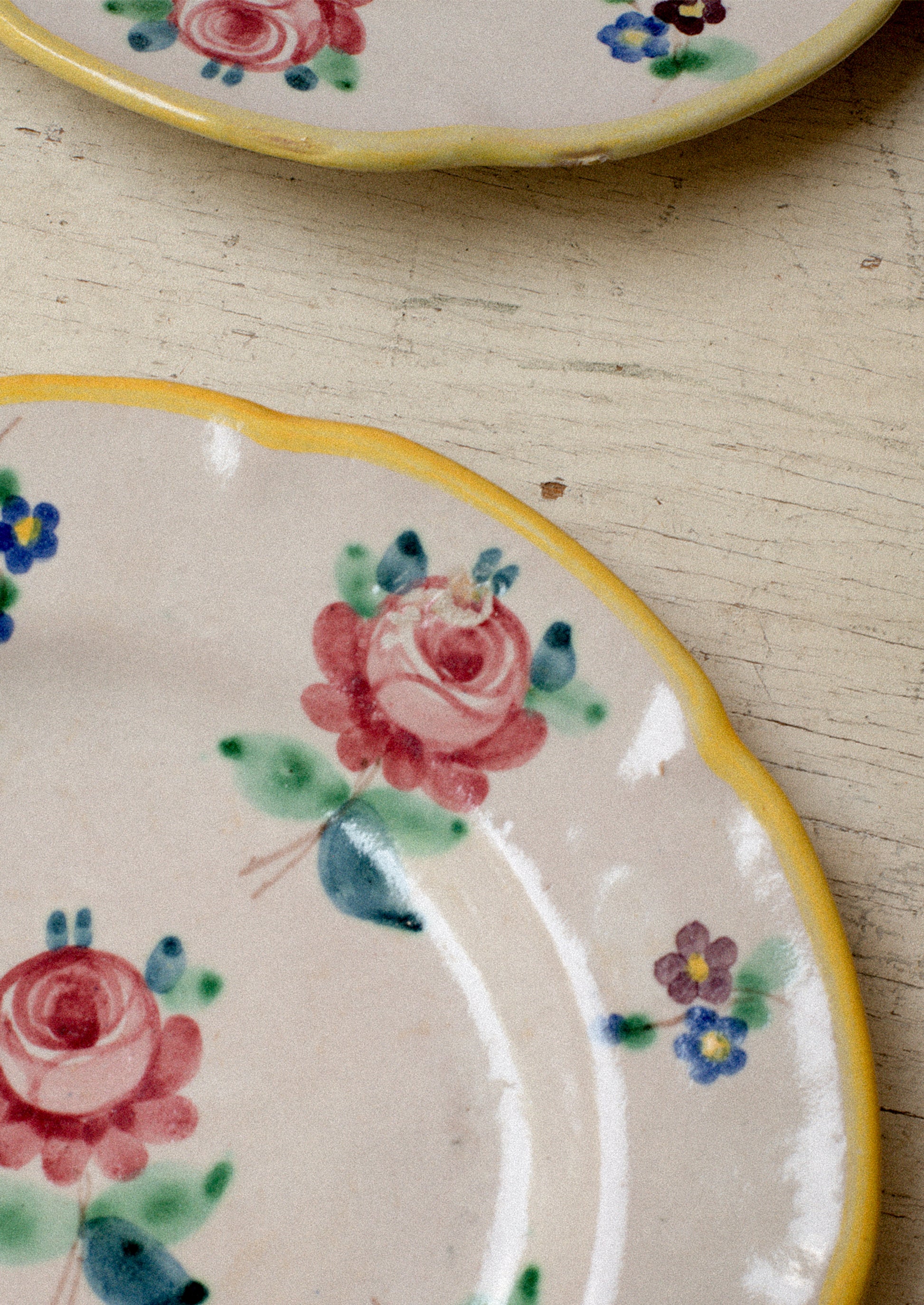 A set of vintage Italian hand painted floral plates with yellow rim.