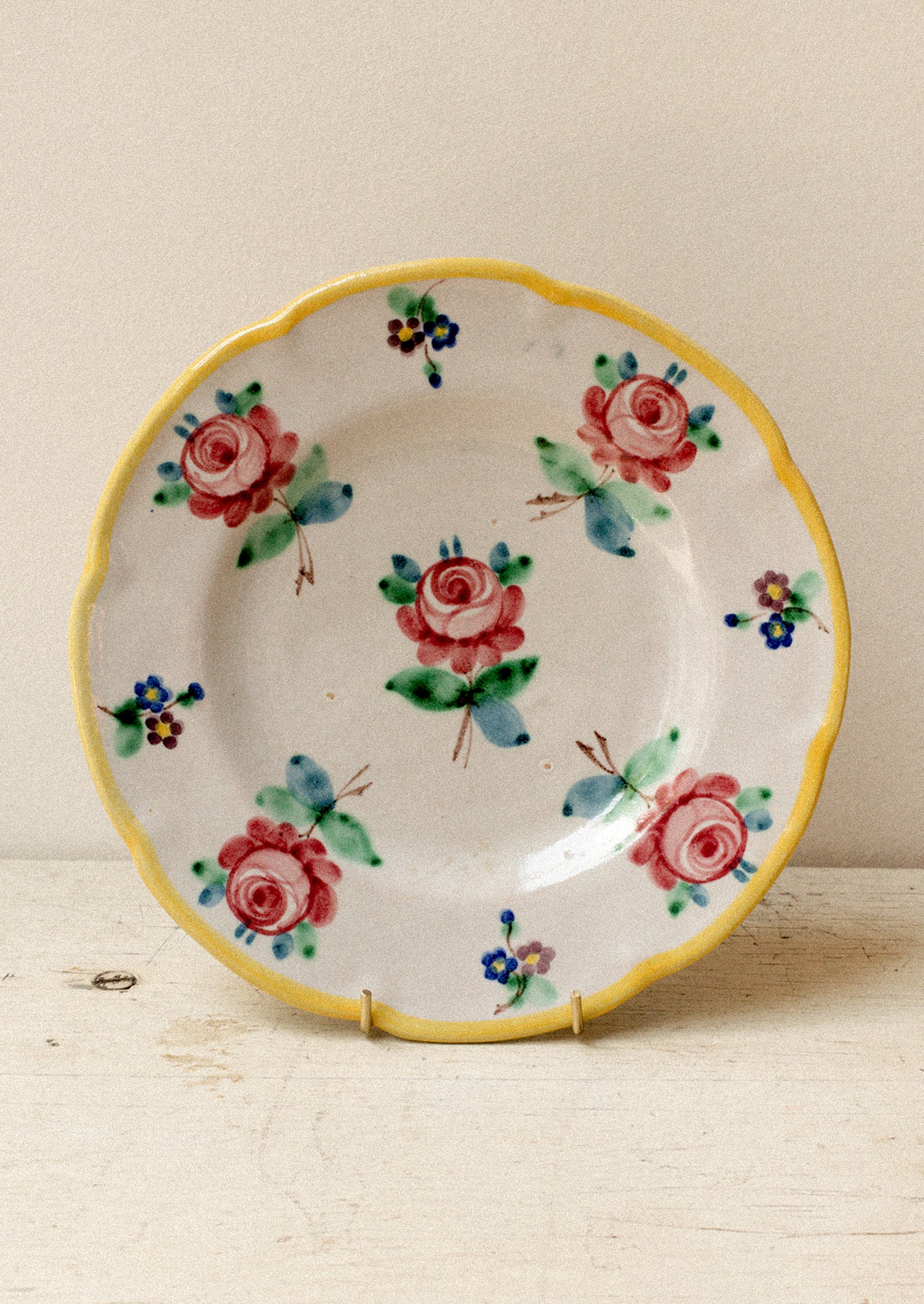 A set of vintage Italian hand painted floral plates with yellow rim.
