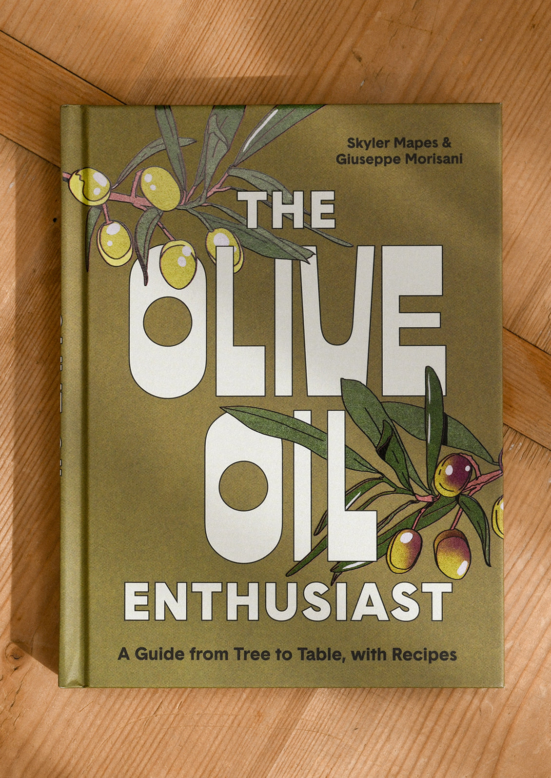 Book titled 'The Olive Oil Enthusiast' on a wooden surface