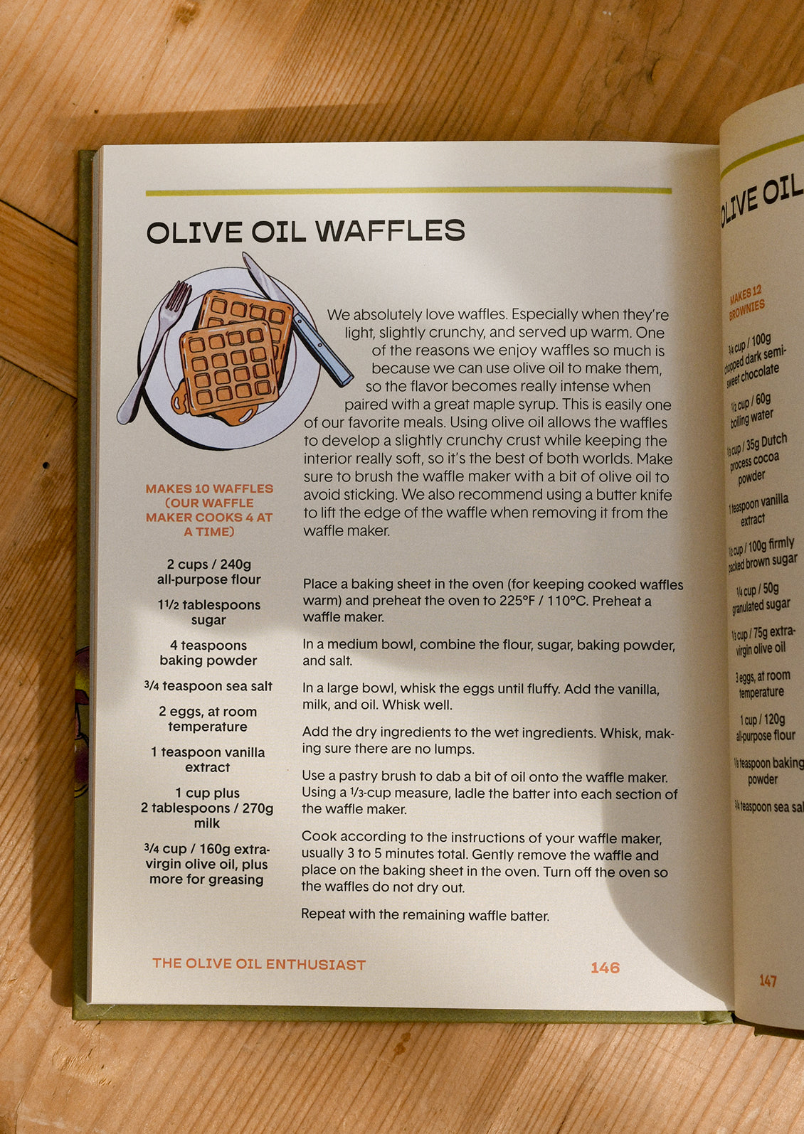 Open cookbook page with olive oil waffles recipe on a wooden surface