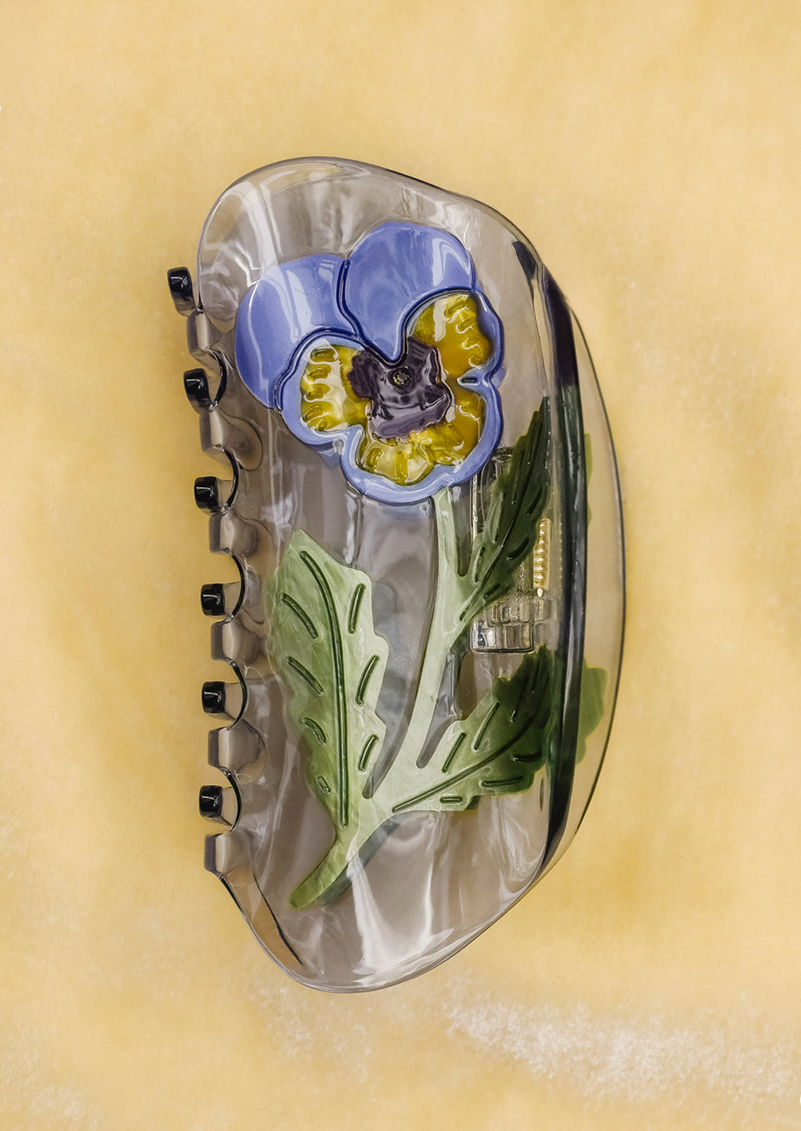 A transparent hair claw with pansy motif.