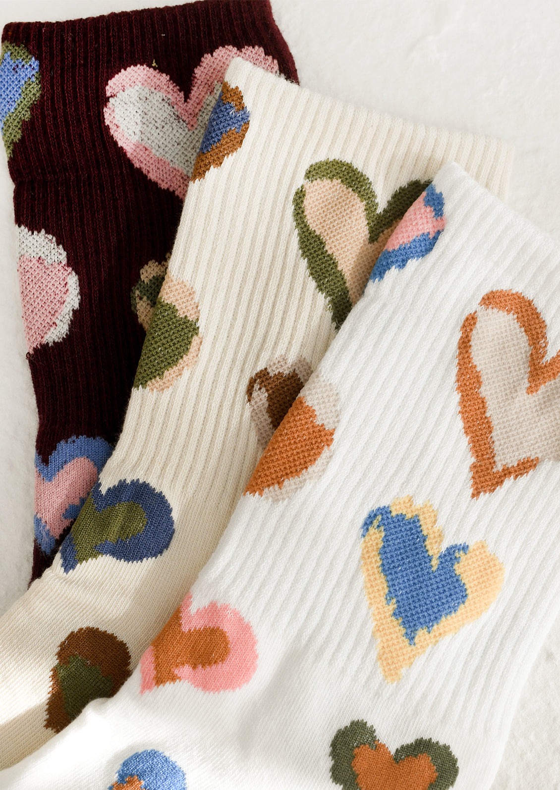 Colorful heart-patterned socks in three color options.