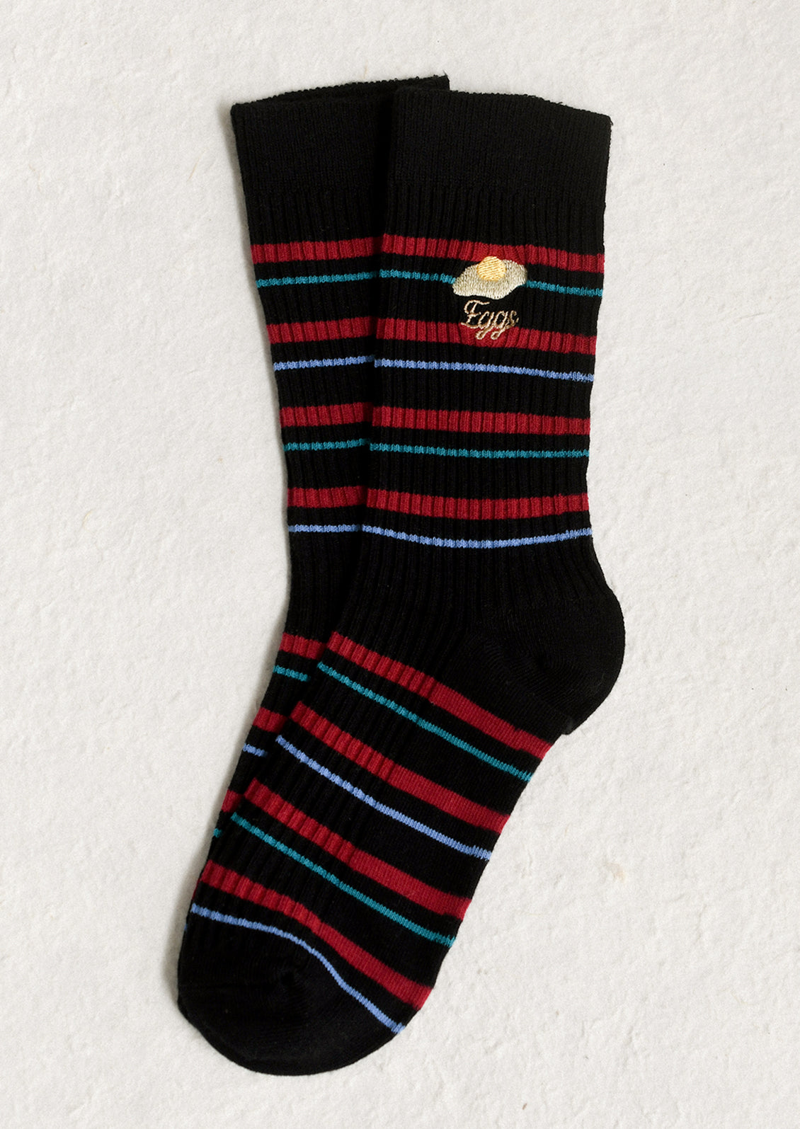 A pair of black socks with red stripe and 'eggs' embroidery motif.