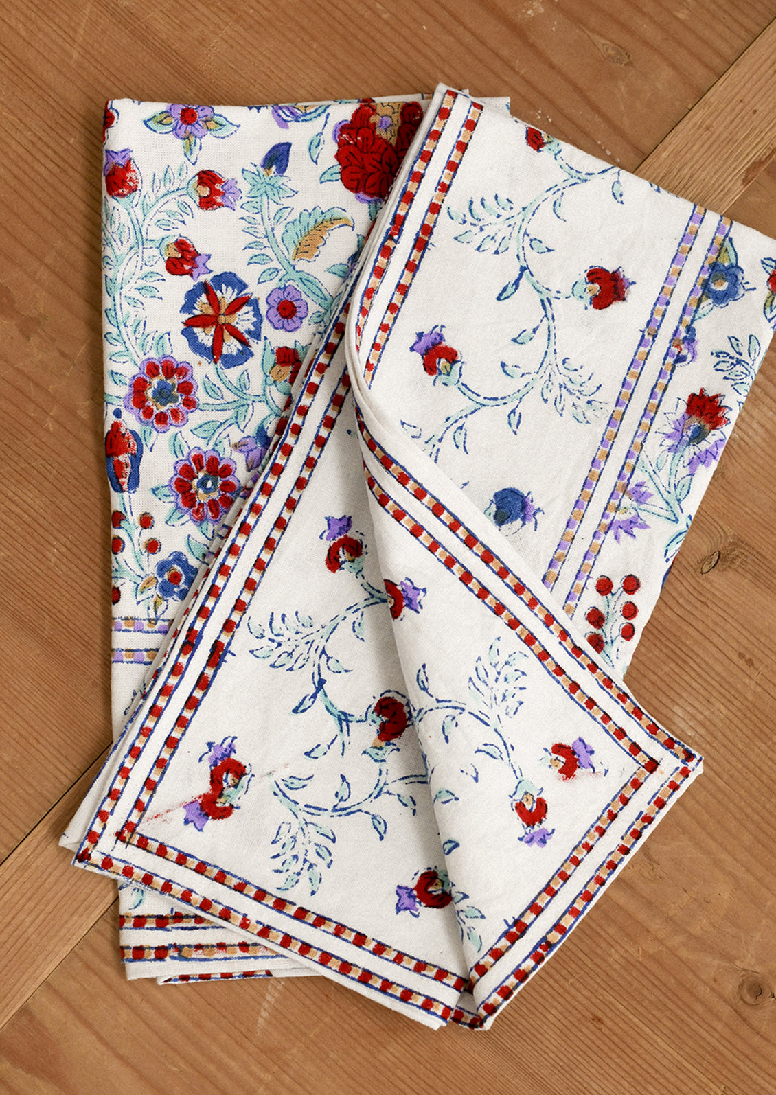 Set of floral patterned napkins on a wooden surface