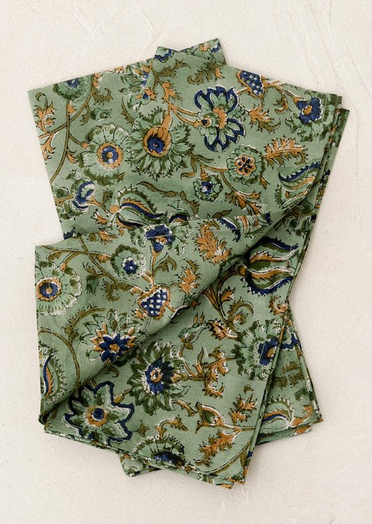 Folded green napkins with floral pattern on a white background