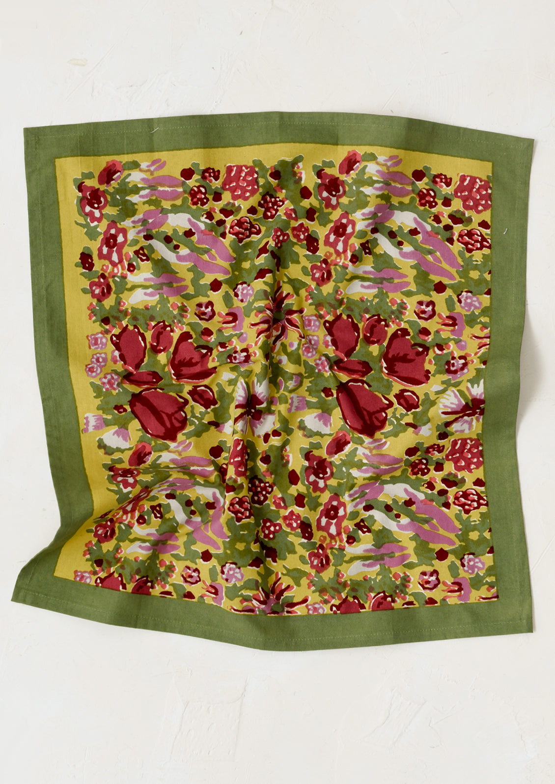 A pair of napkins in green block printed floral pattern.