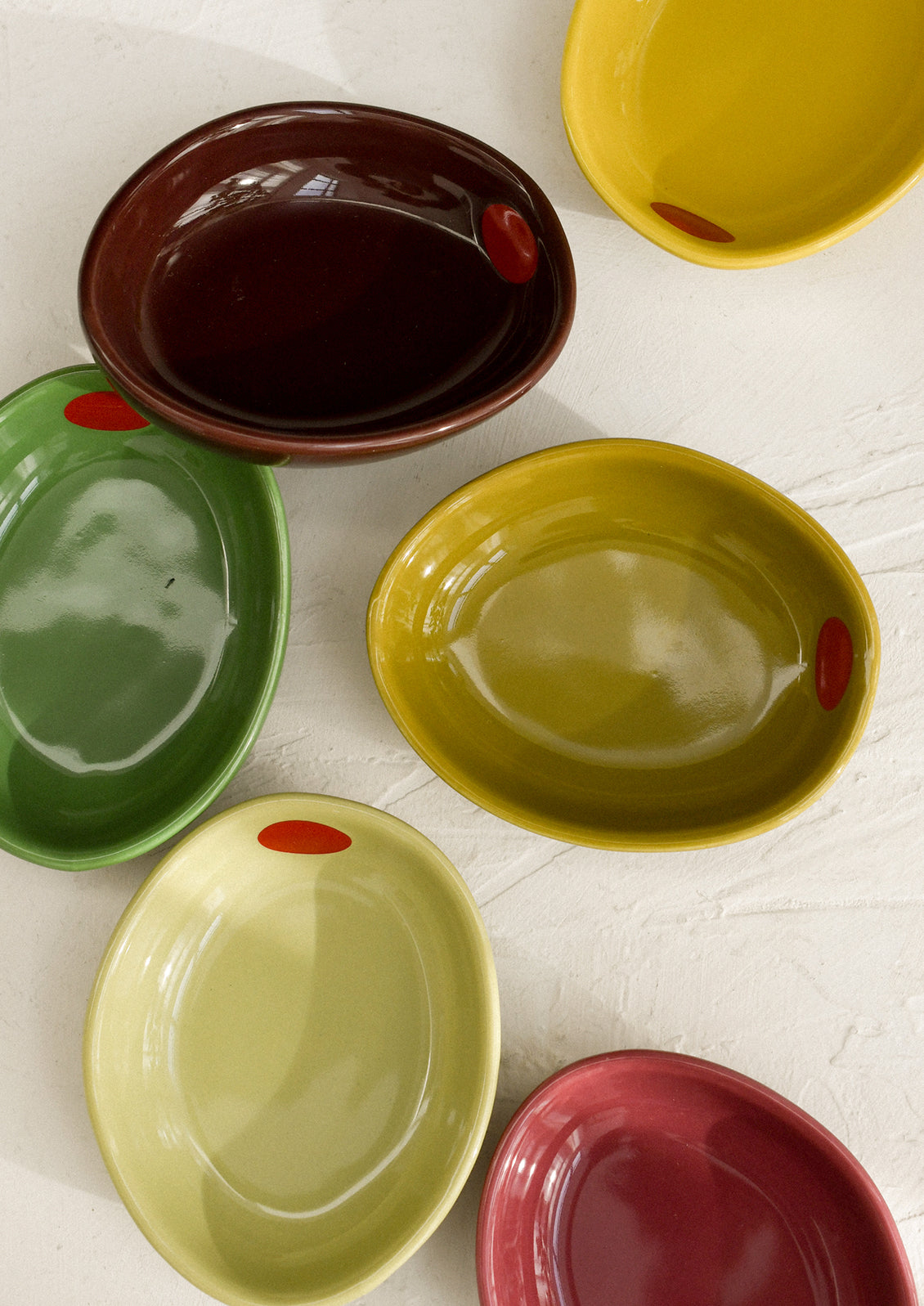 Small ceramic bowls shaped like olives in an assortment of colors.