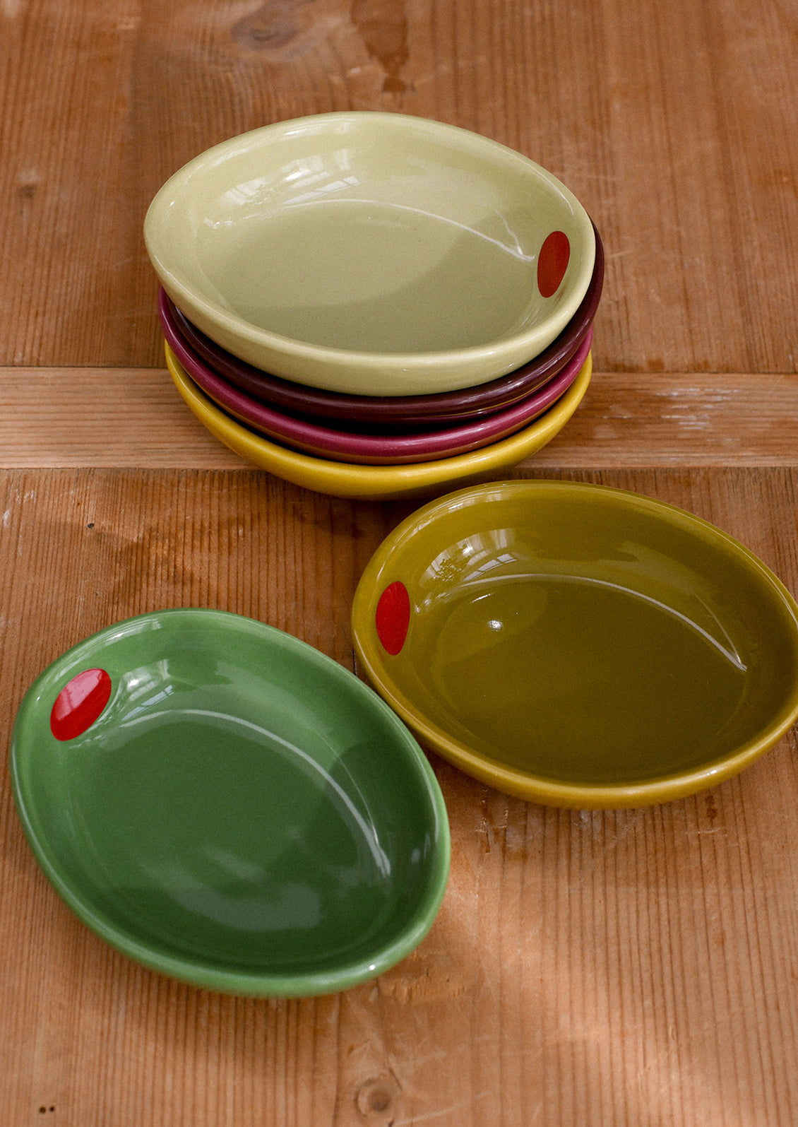 Small ceramic bowls shaped like olives in an assortment of colors.