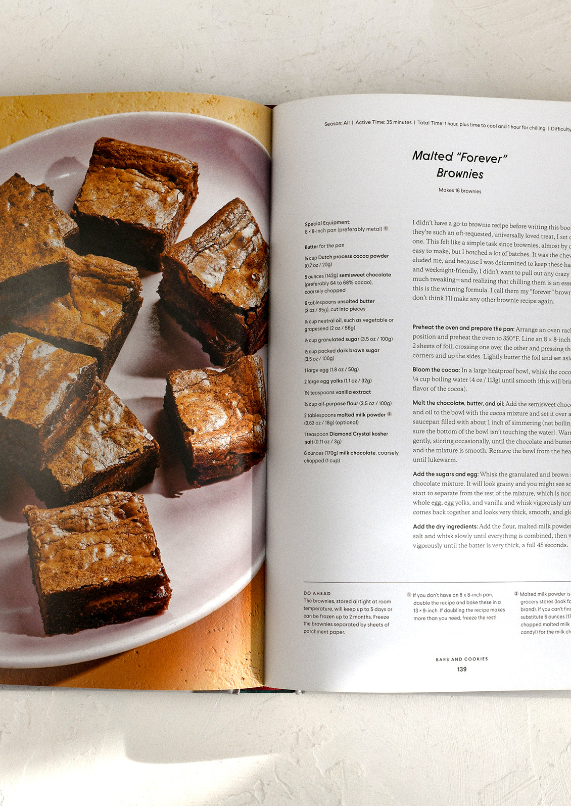 Open cookbook showing a plate of brownies and a recipe for Malted 'Forever' Brownies.