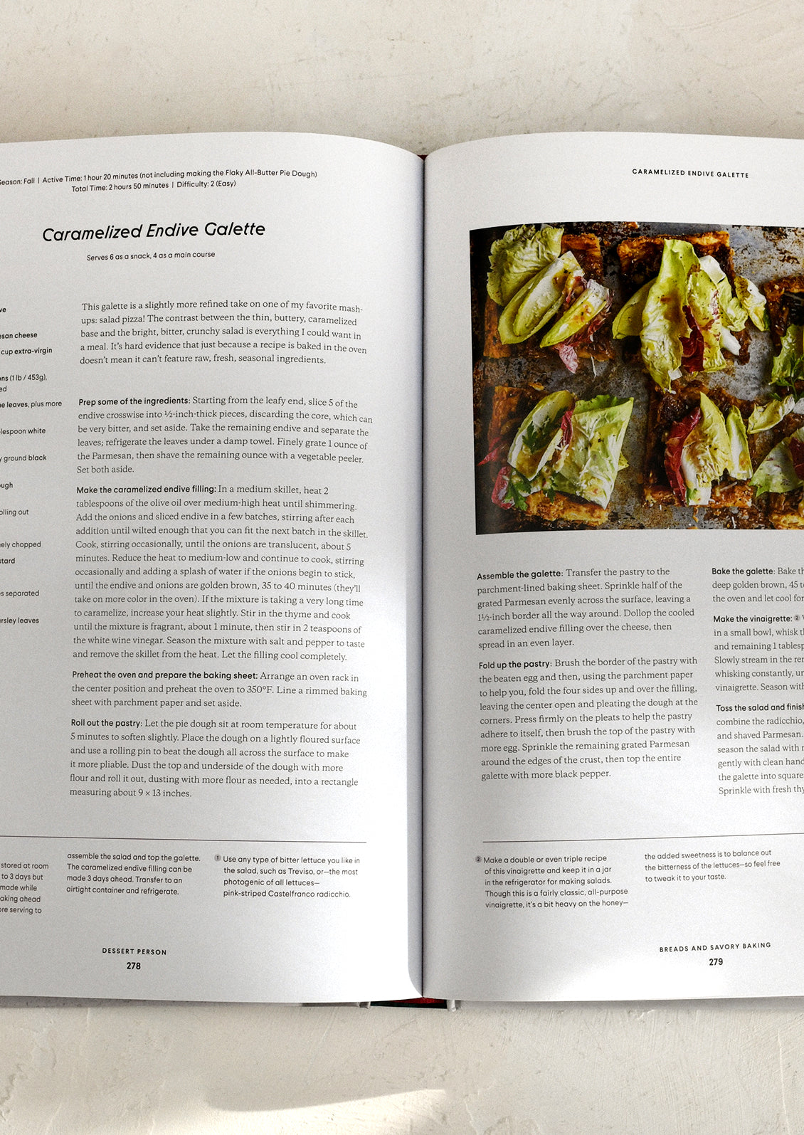 Open cookbook showing a recipe for Caramelized Endive Galette with an image of the dish on a light background.
