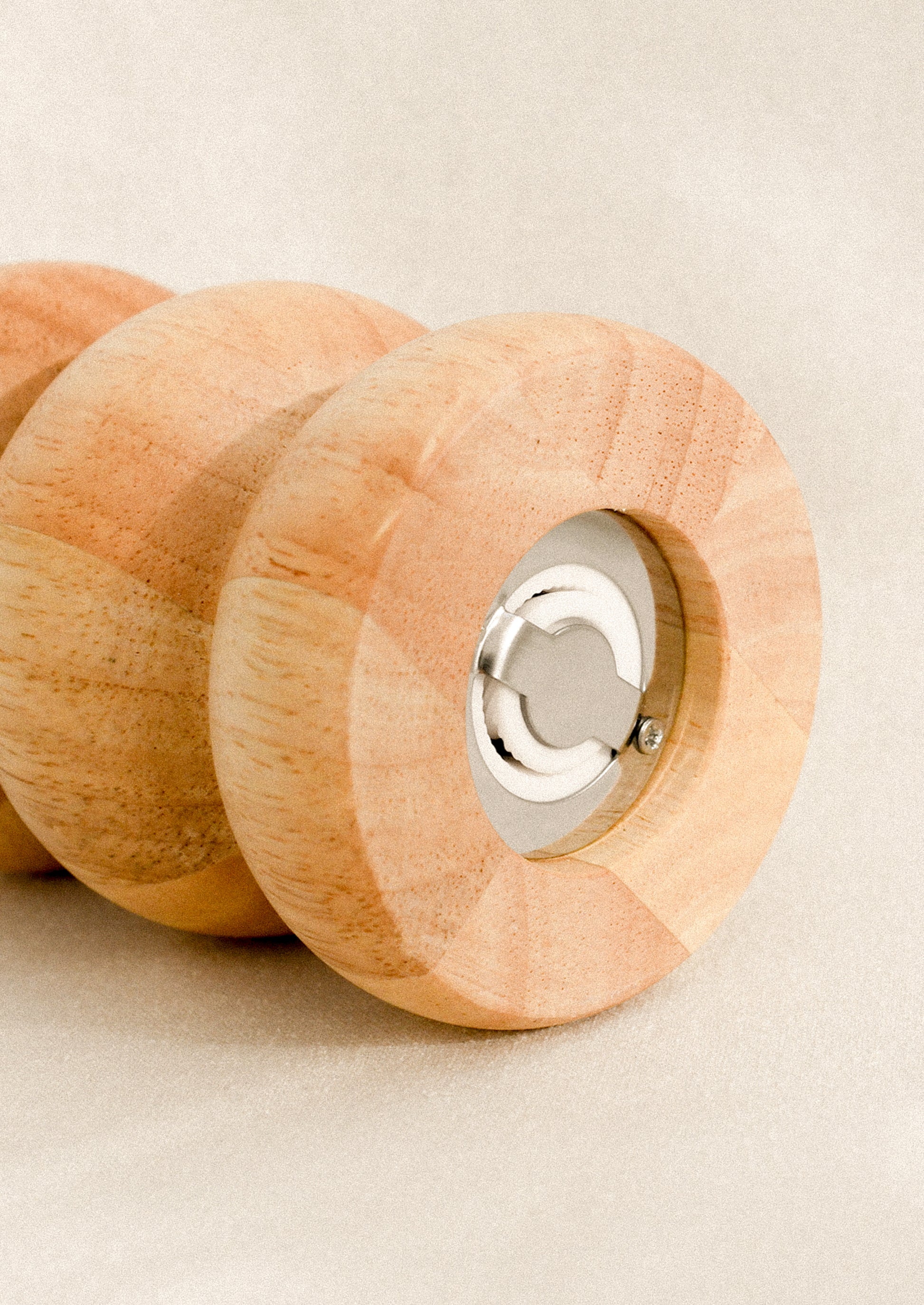 Wooden pepper grinder with metal grinding mechanism at bottom.