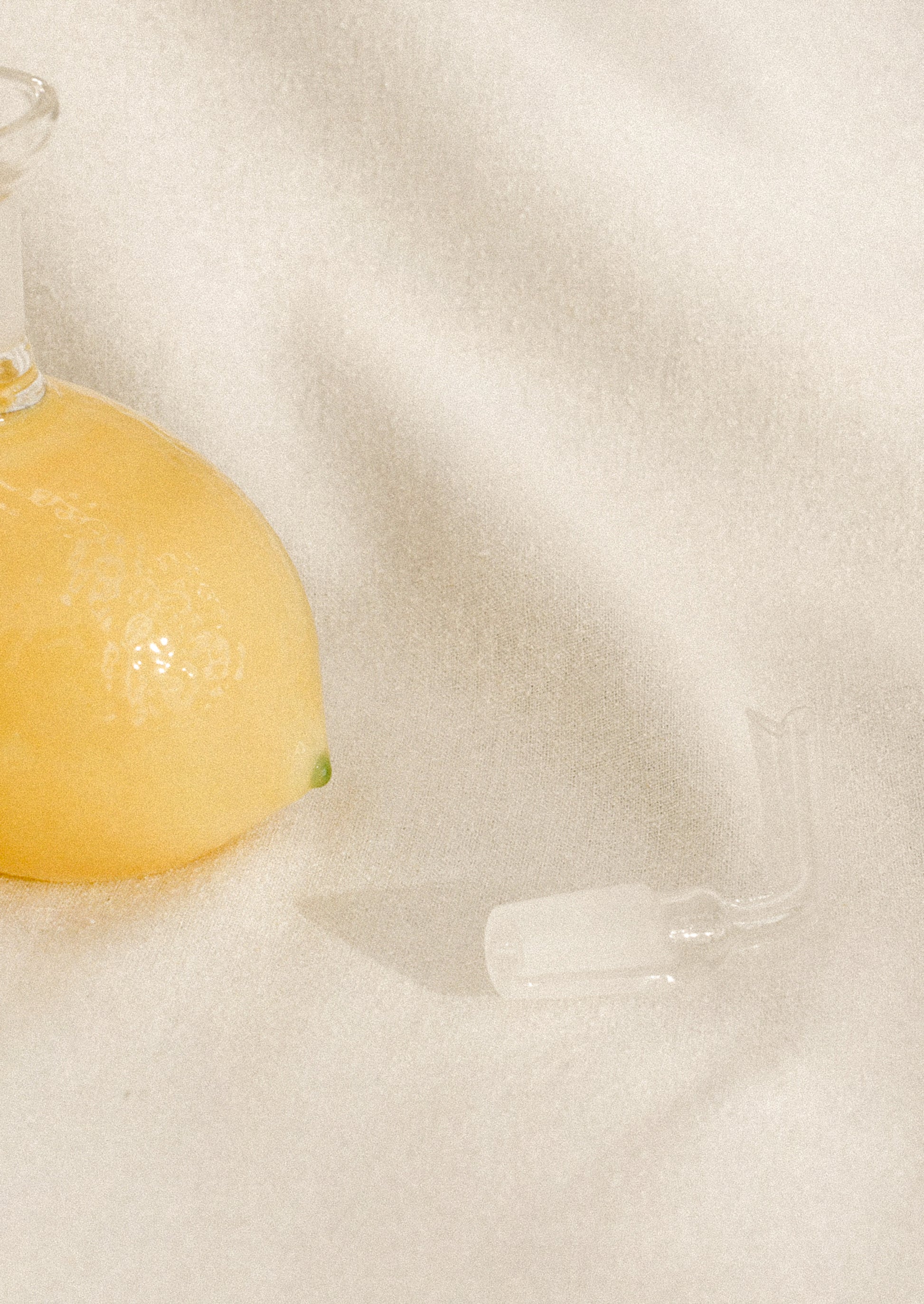 A small glass cruet bottle shaped like a lemon, in yellow with green tips.