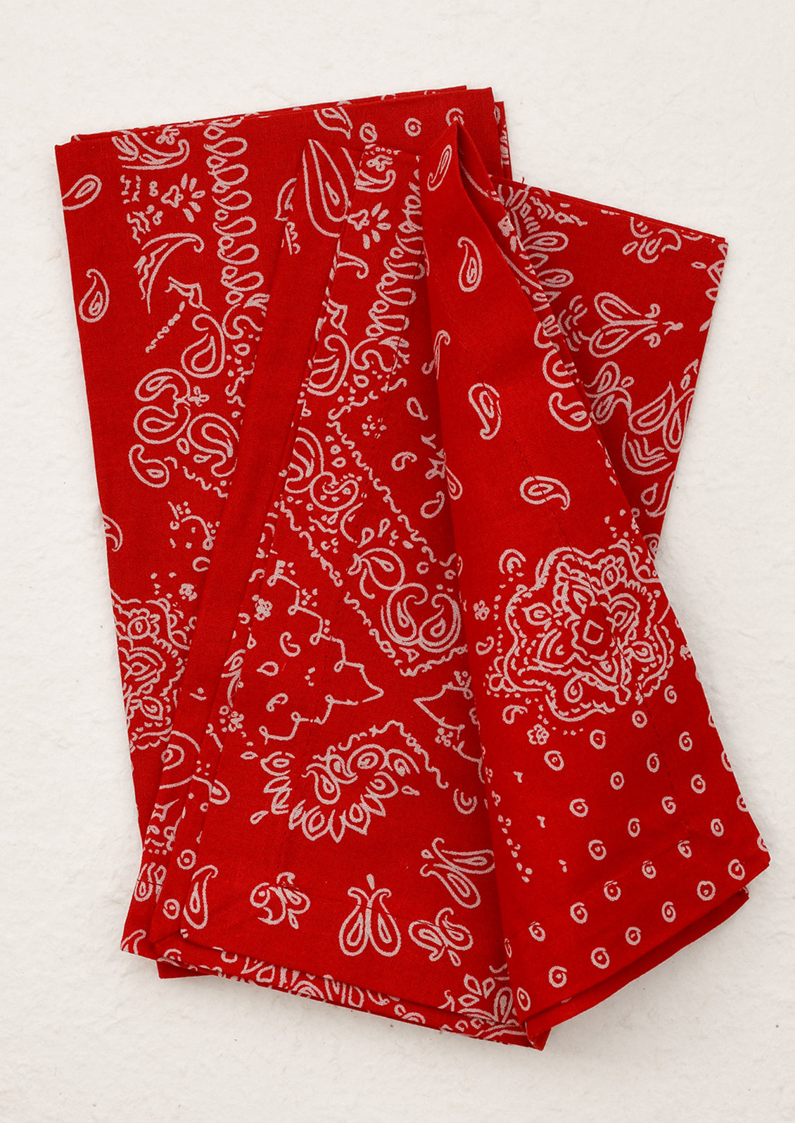 A pair of napkins in red with white bandana pattern.
