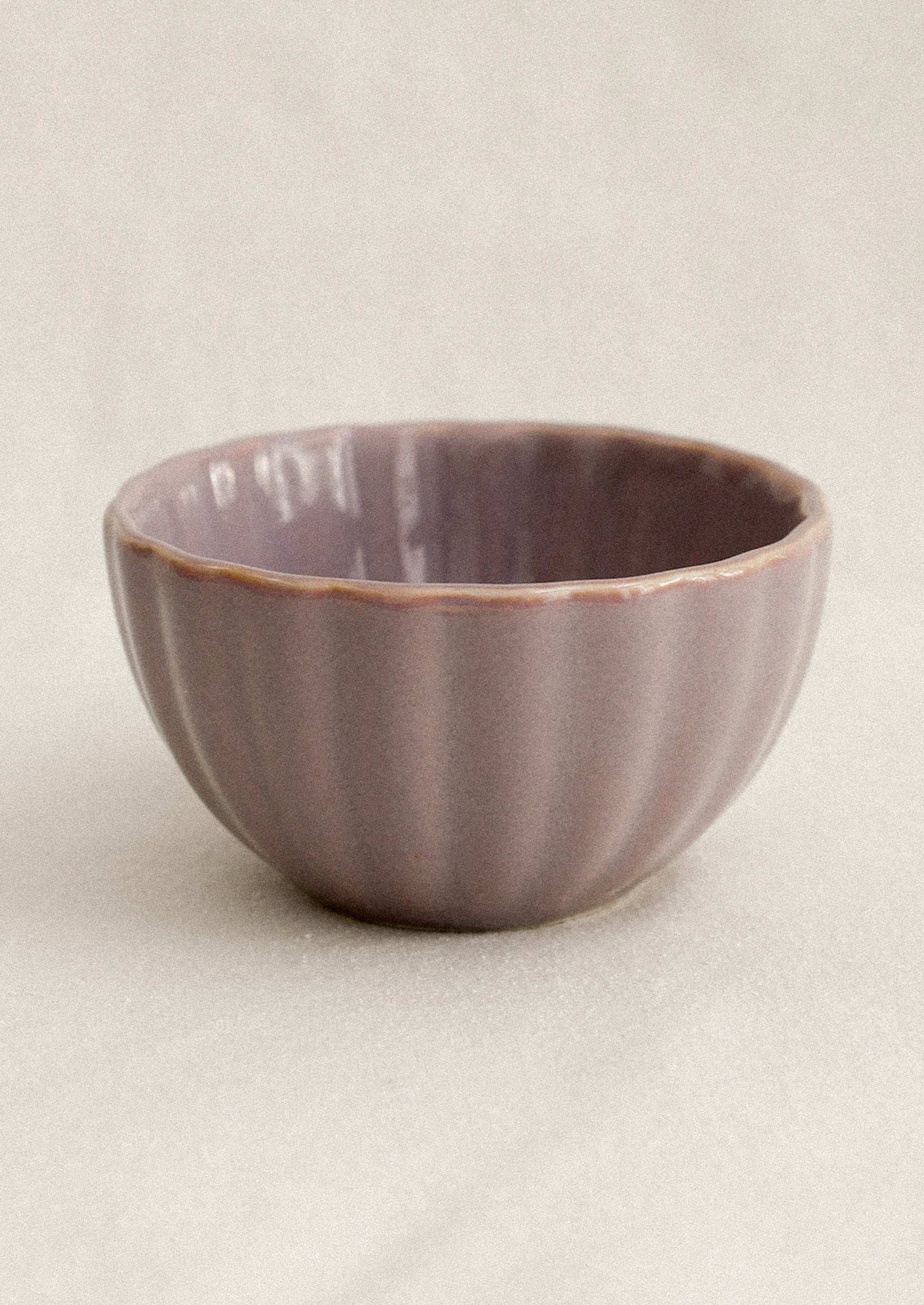Purple ceramic bowl on a beige background