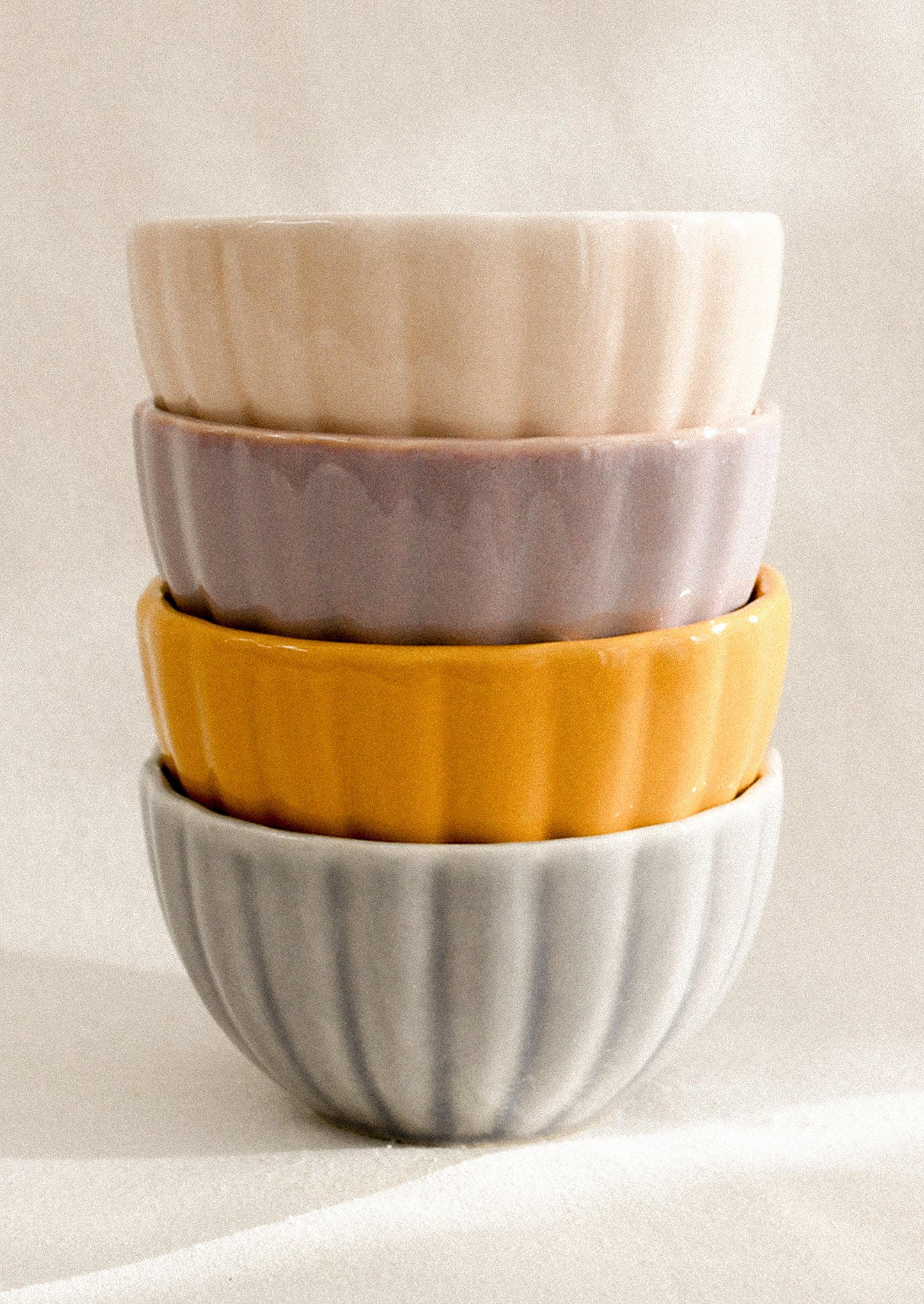 A stack of colorful ceramic bowls with ribbed texture.