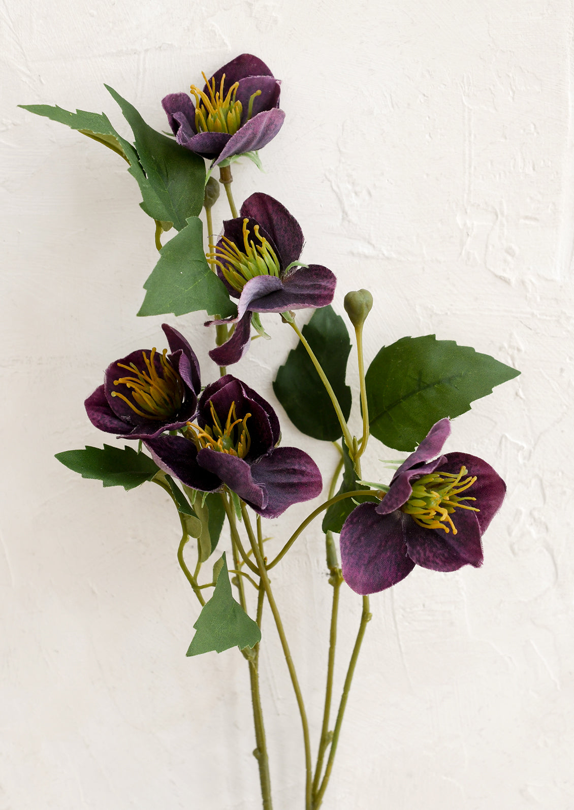 Artificial purple flowers with green leaves on a white background